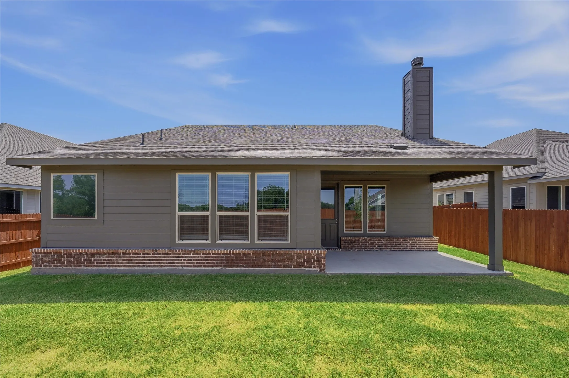 Shingle roof with a covered patio and a brick and siding exterior