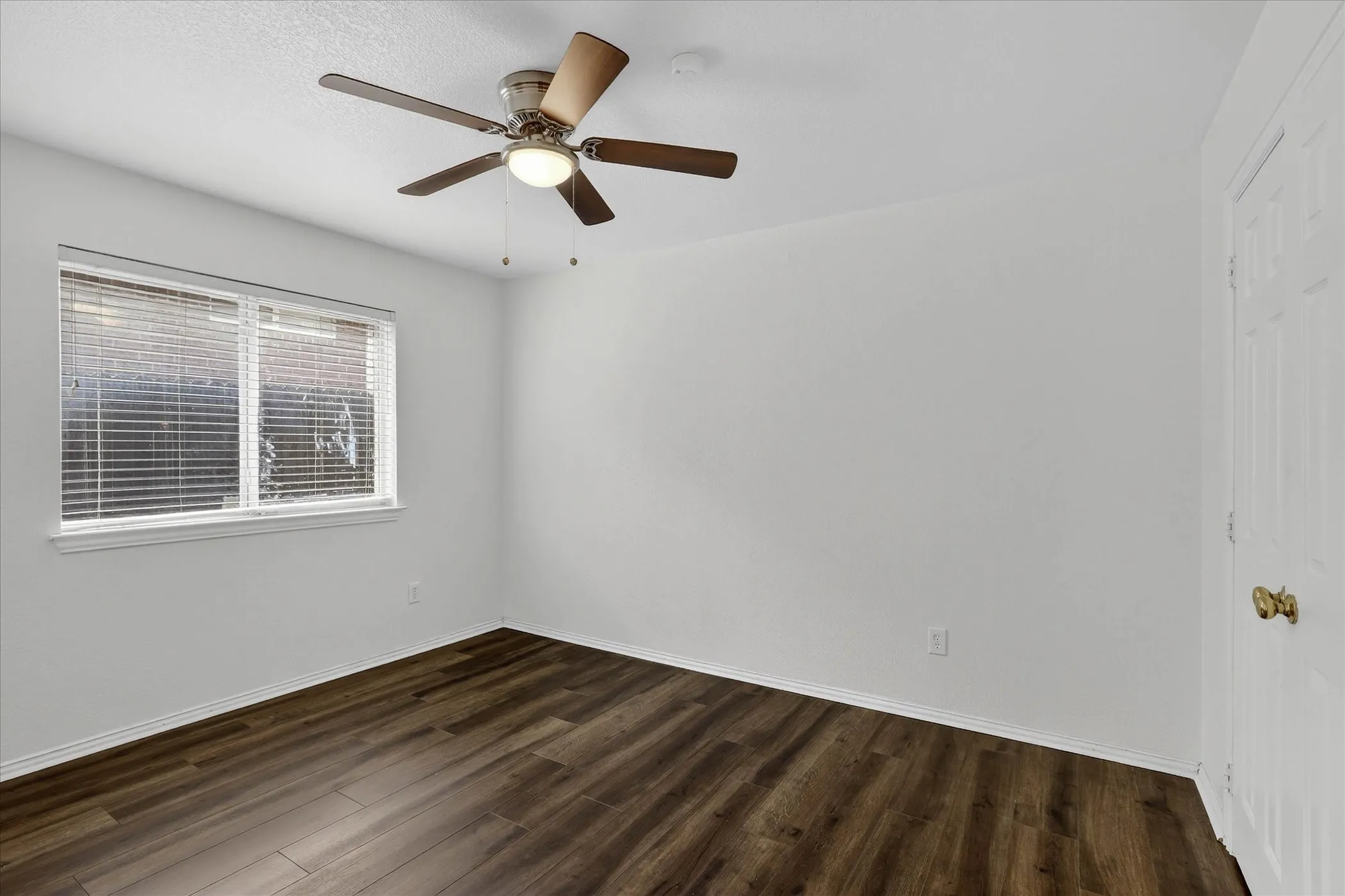 Spare room with dark wood-style floors and ceiling fan