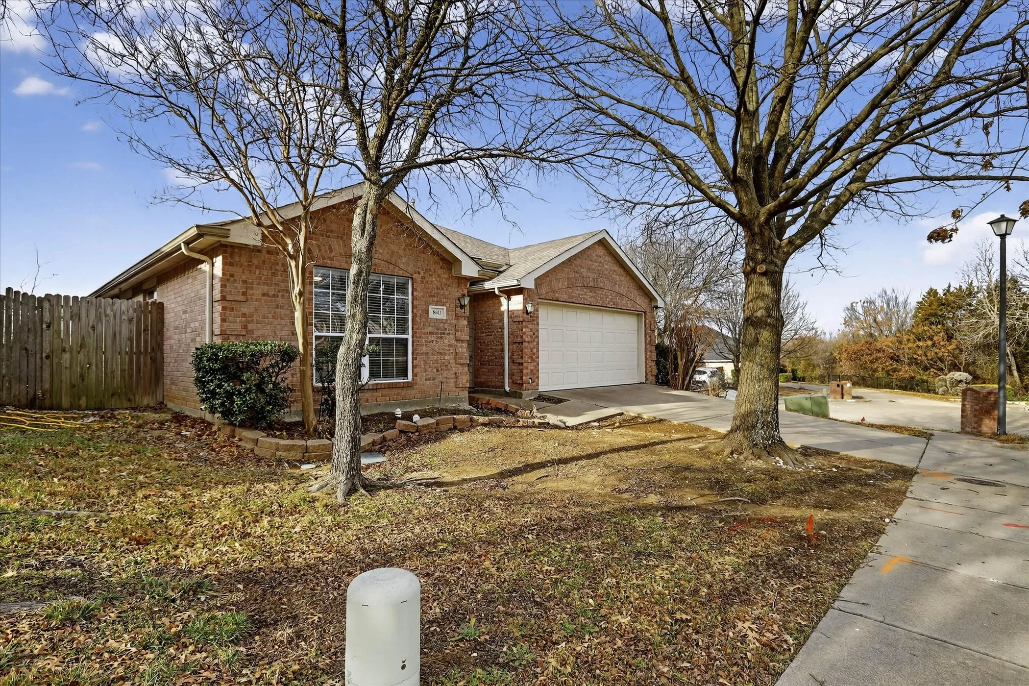 View of front of home featuring brick siding, concrete driveway, and an attached garage