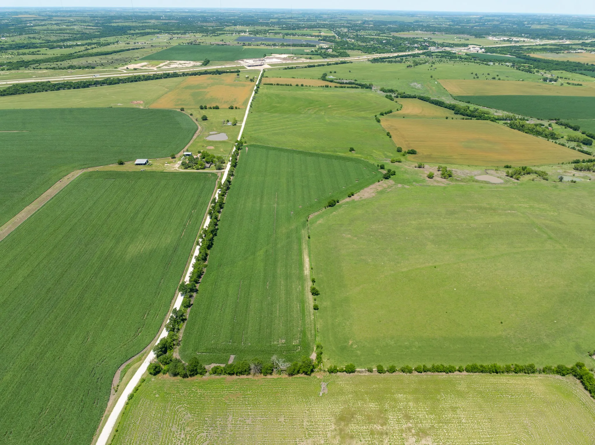 Aerial view of sparsely populated area with large plots for crops