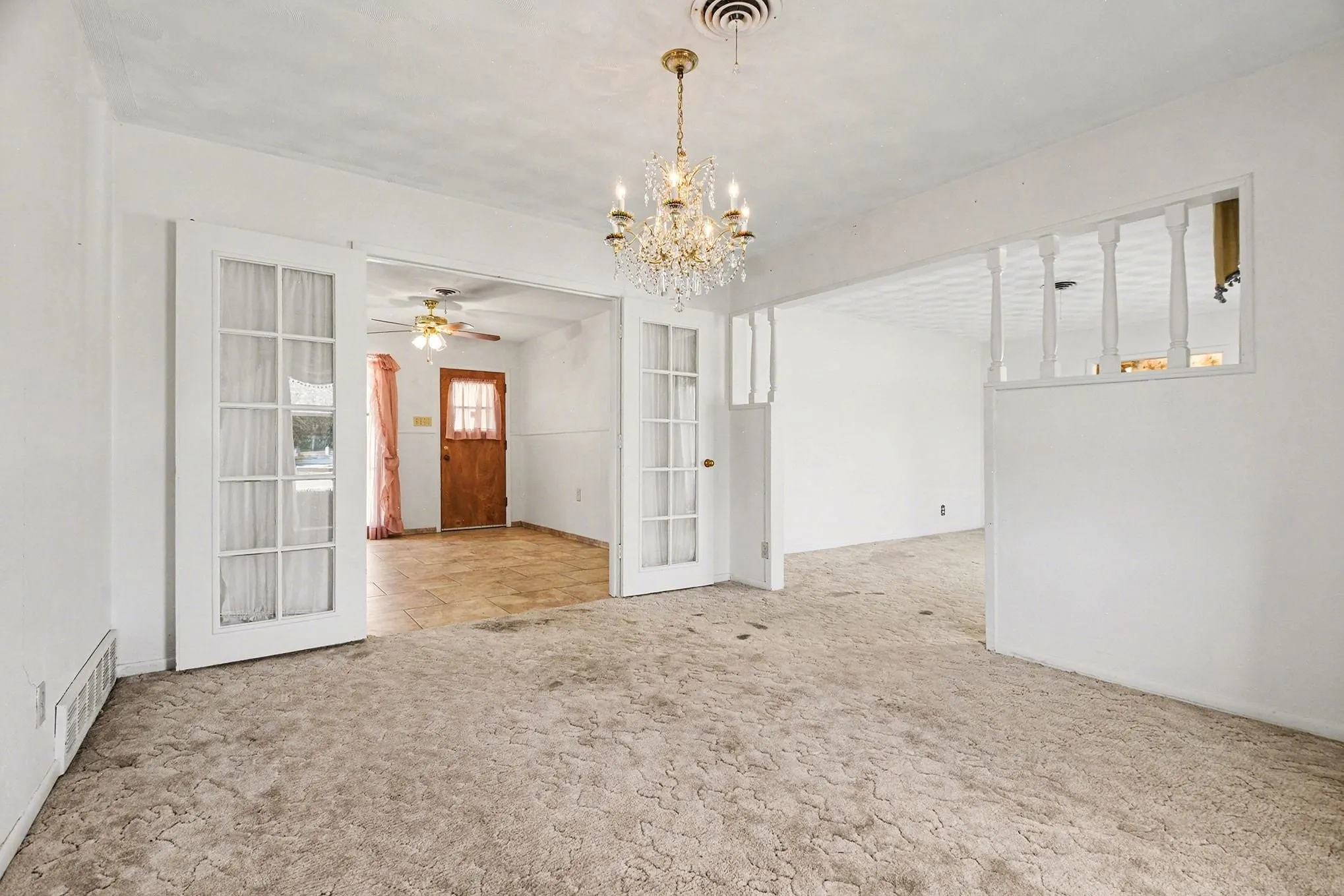Spare room with hanging lights, light colored carpet, a ceiling fan, and french doors