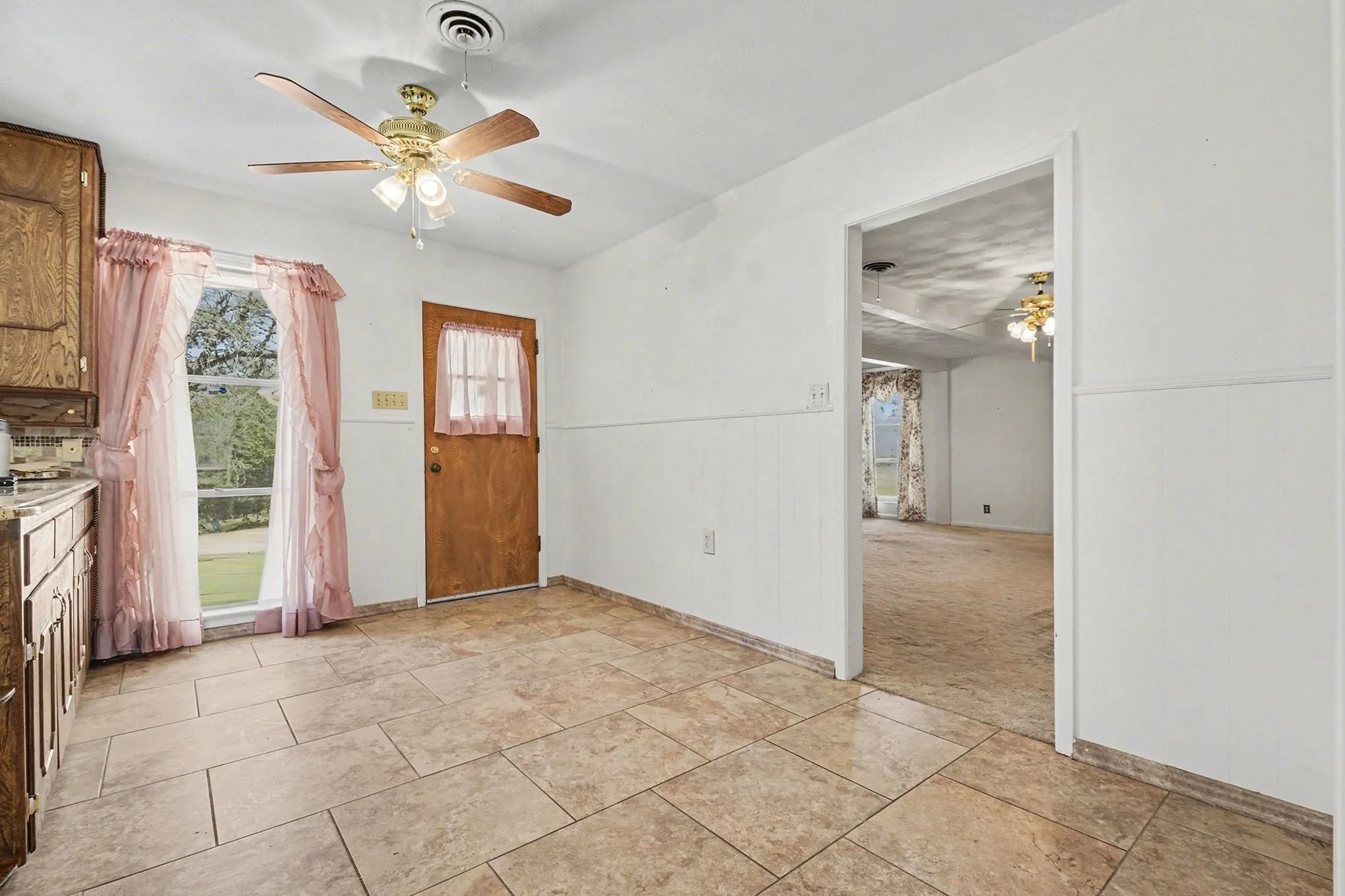 Foyer with a ceiling fan and baseboards