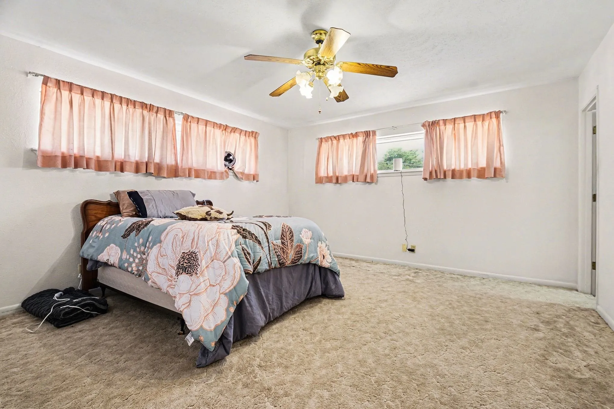 Carpeted bedroom with ceiling fan and baseboards