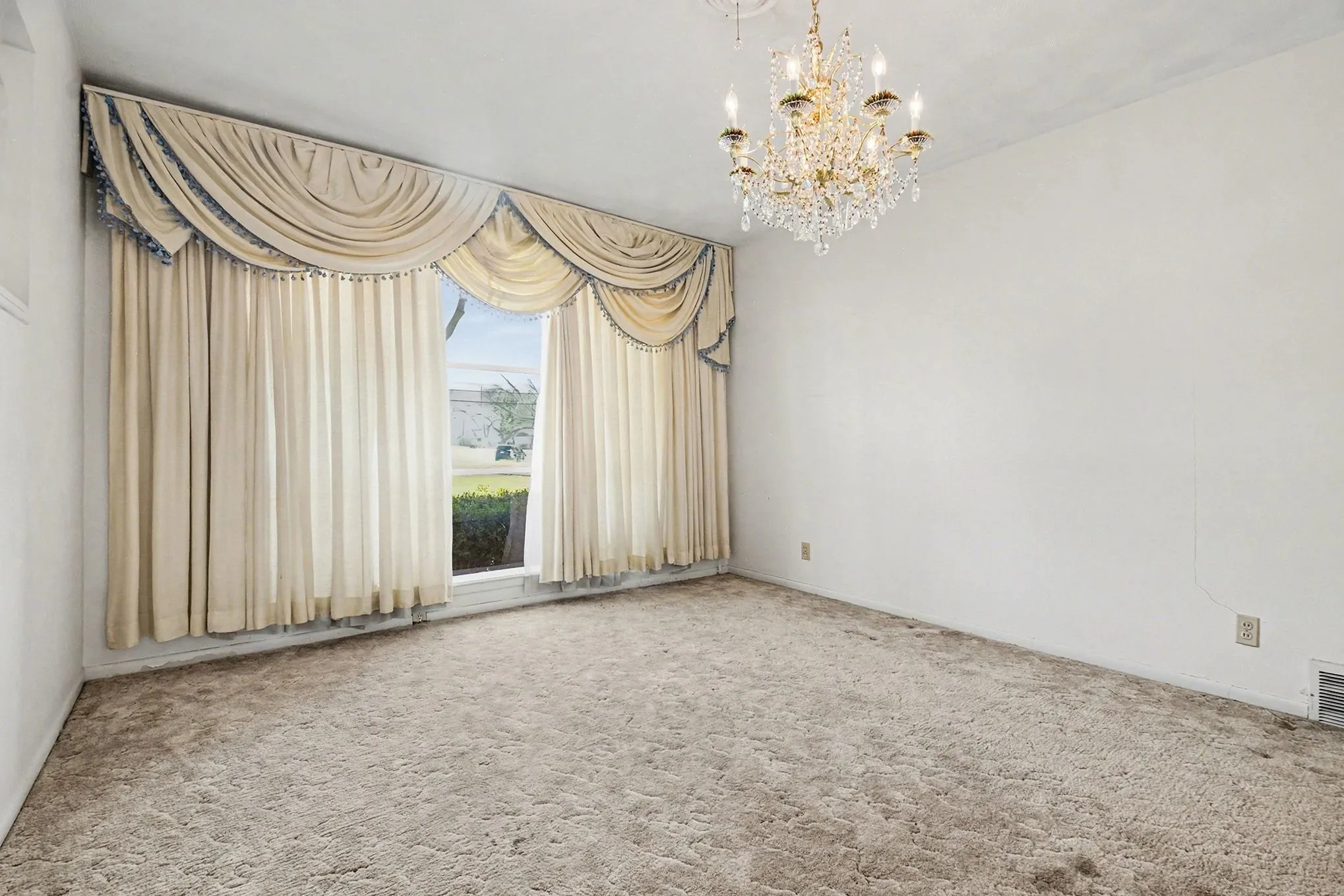 Spare room with hanging lights and carpet