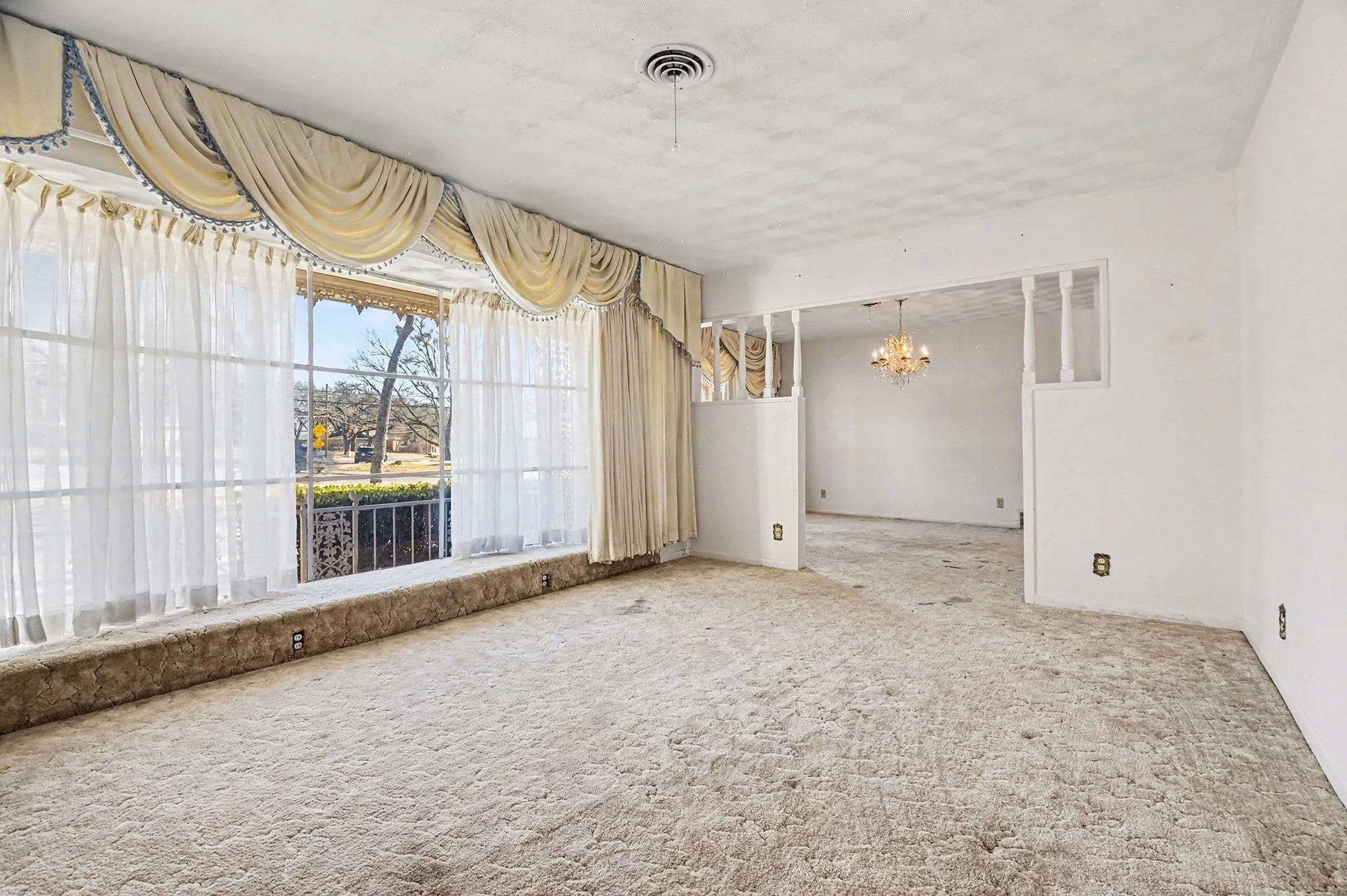 Carpeted spare room featuring suspended lighting