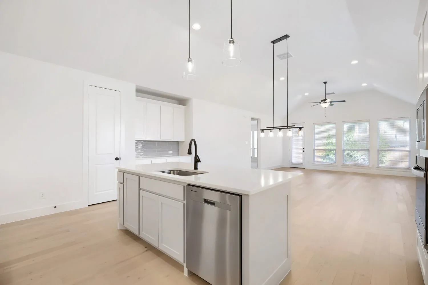 Kitchen island with an undermount sink, gooseneck faucet, and stainless steel dishwasher