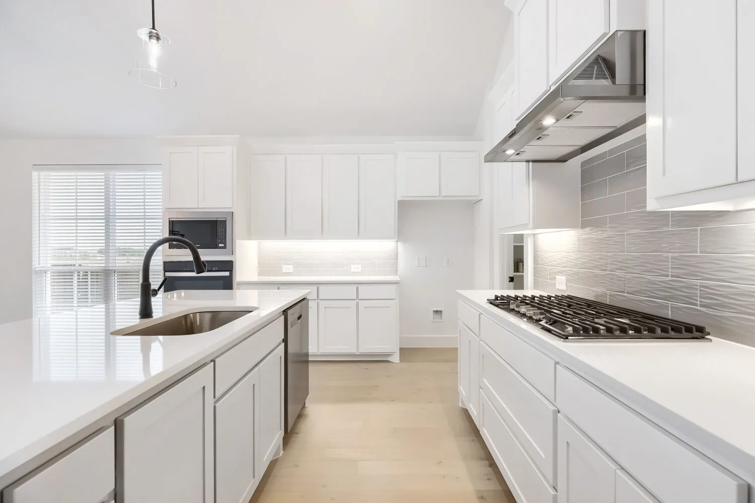 Modern kitchen featuring white cabinetry, light wood-finish flooring, and white countertops