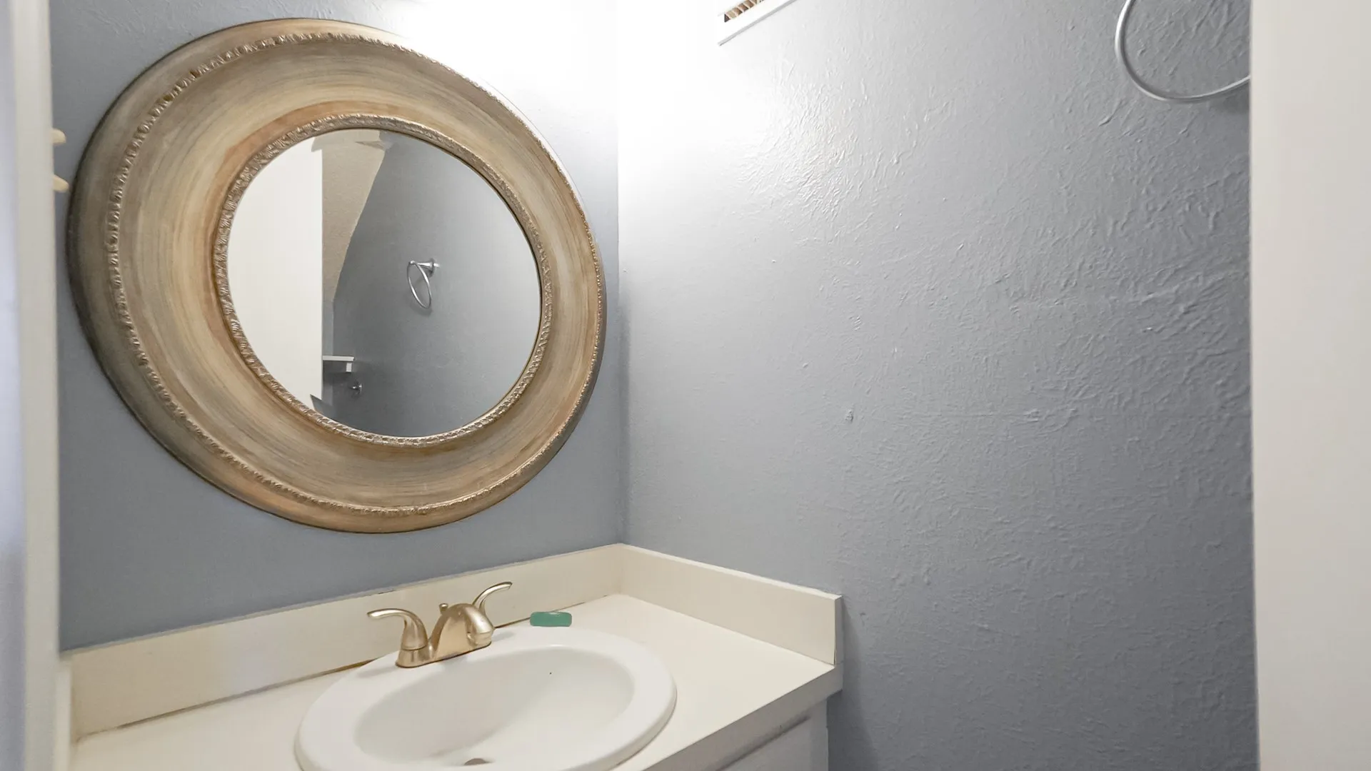 Bathroom with vanity and a textured wall