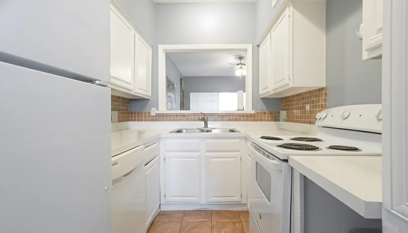Kitchen with white appliances, white cabinetry, light countertops, light tile patterned floors, and ceiling fan