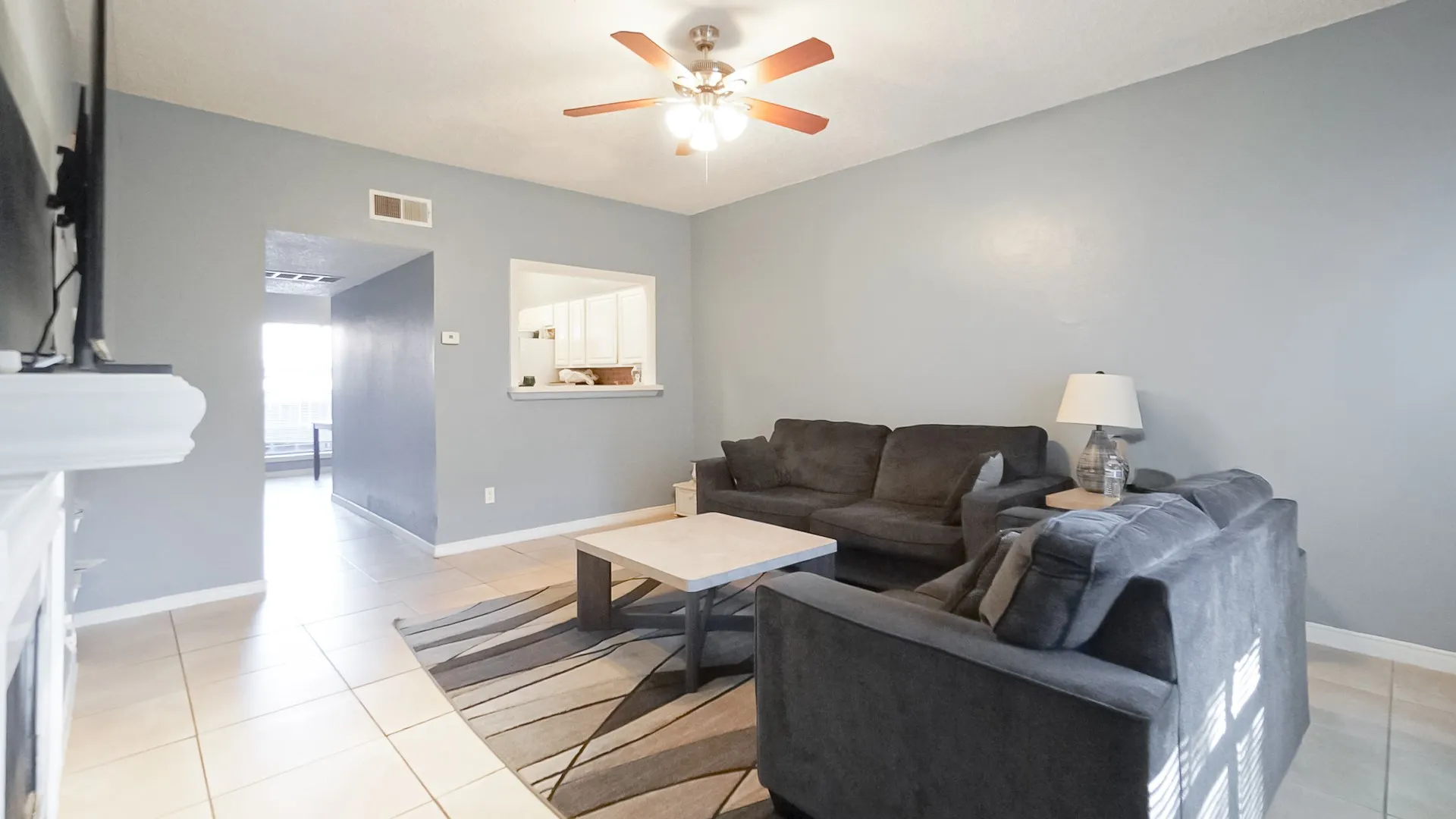 Living area with light tile patterned floors and a ceiling fan
