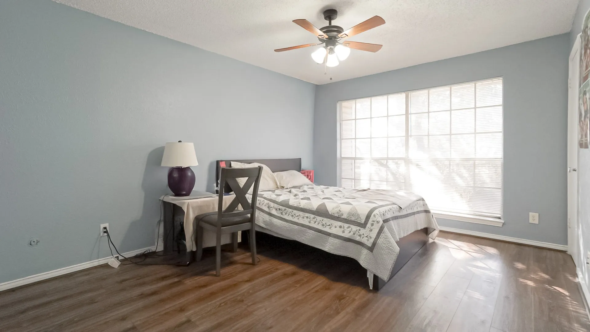 Bedroom with dark wood-style floors, ceiling fan, and a textured ceiling