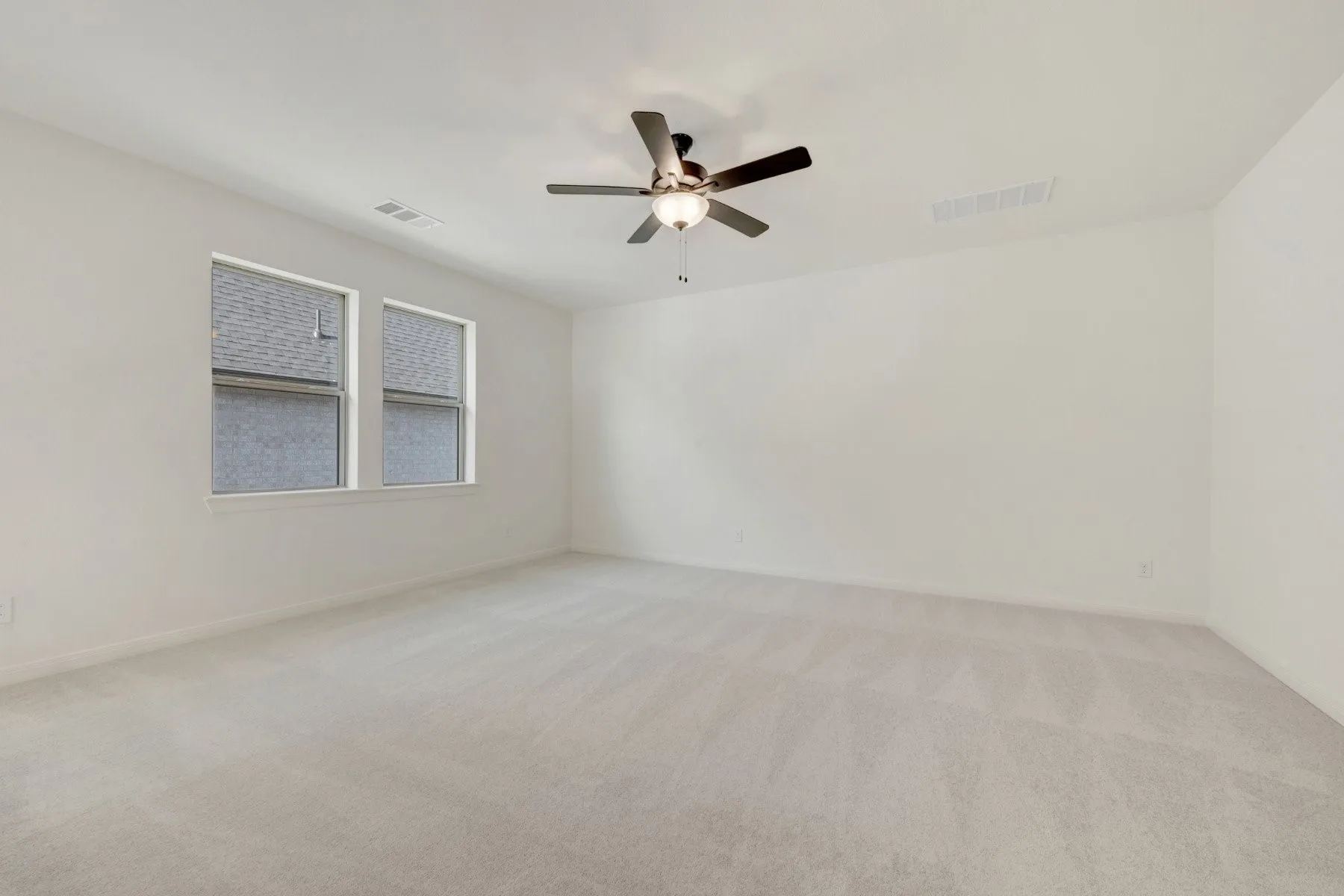 Spacious room featuring light-toned carpeting and neutral wall paint