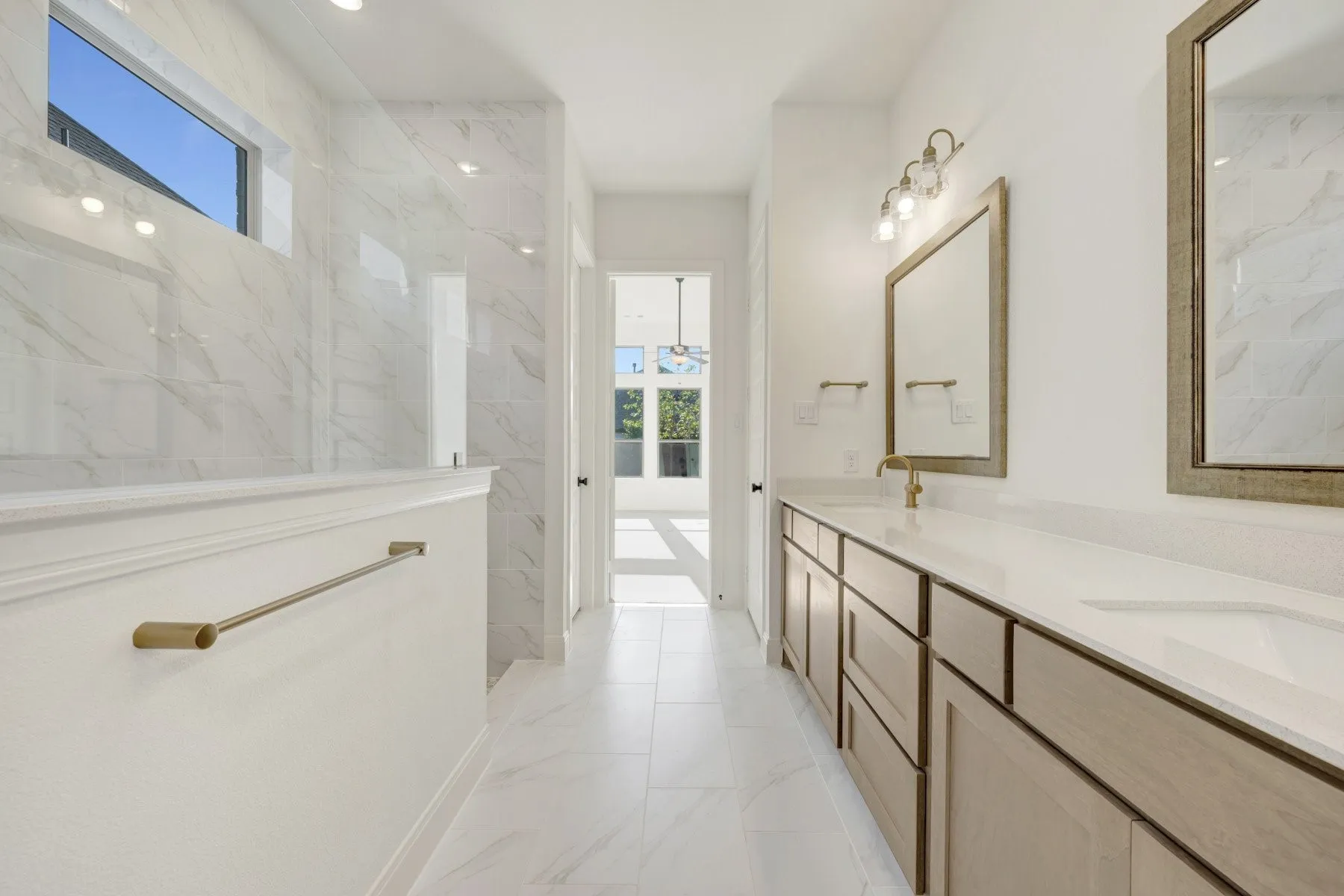 Spacious bathroom featuring a dual vanity with light wood-finish cabinetry, white countertops, and undermount sinks
