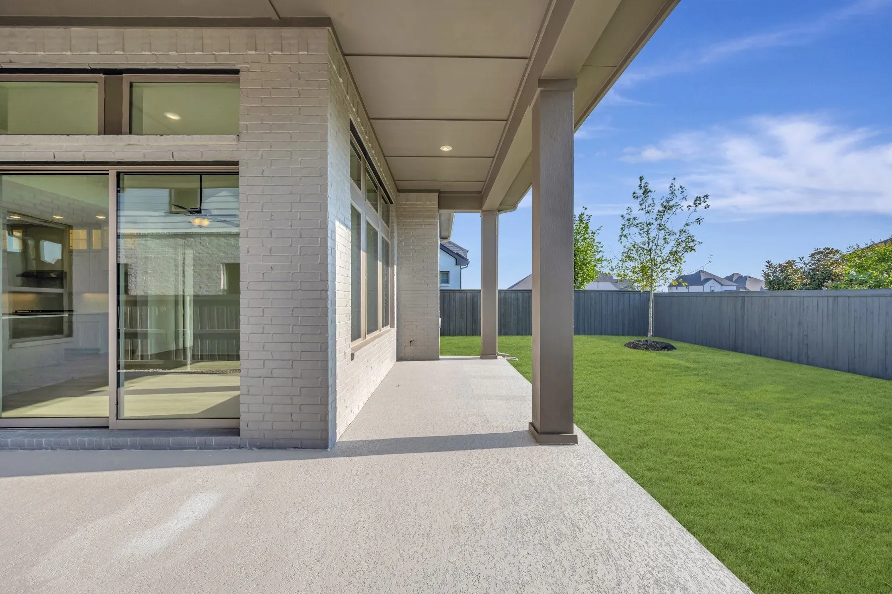 Covered patio featuring a concrete surface, supported by columns