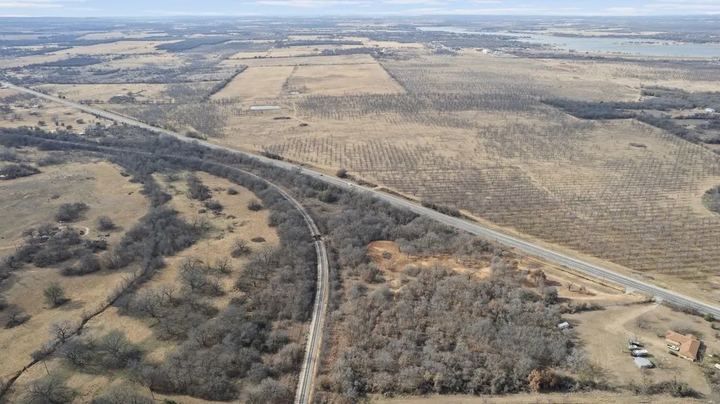 Aerial overview of property's location featuring in clearing the well pump house and pond in the clearing