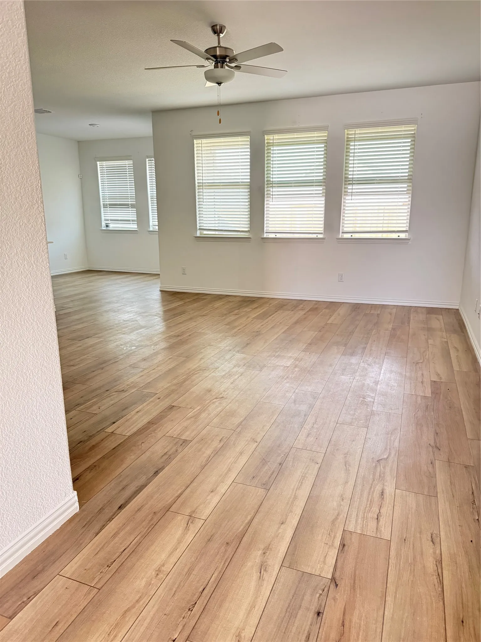 Unfurnished room with a ceiling fan and light wood-type flooring