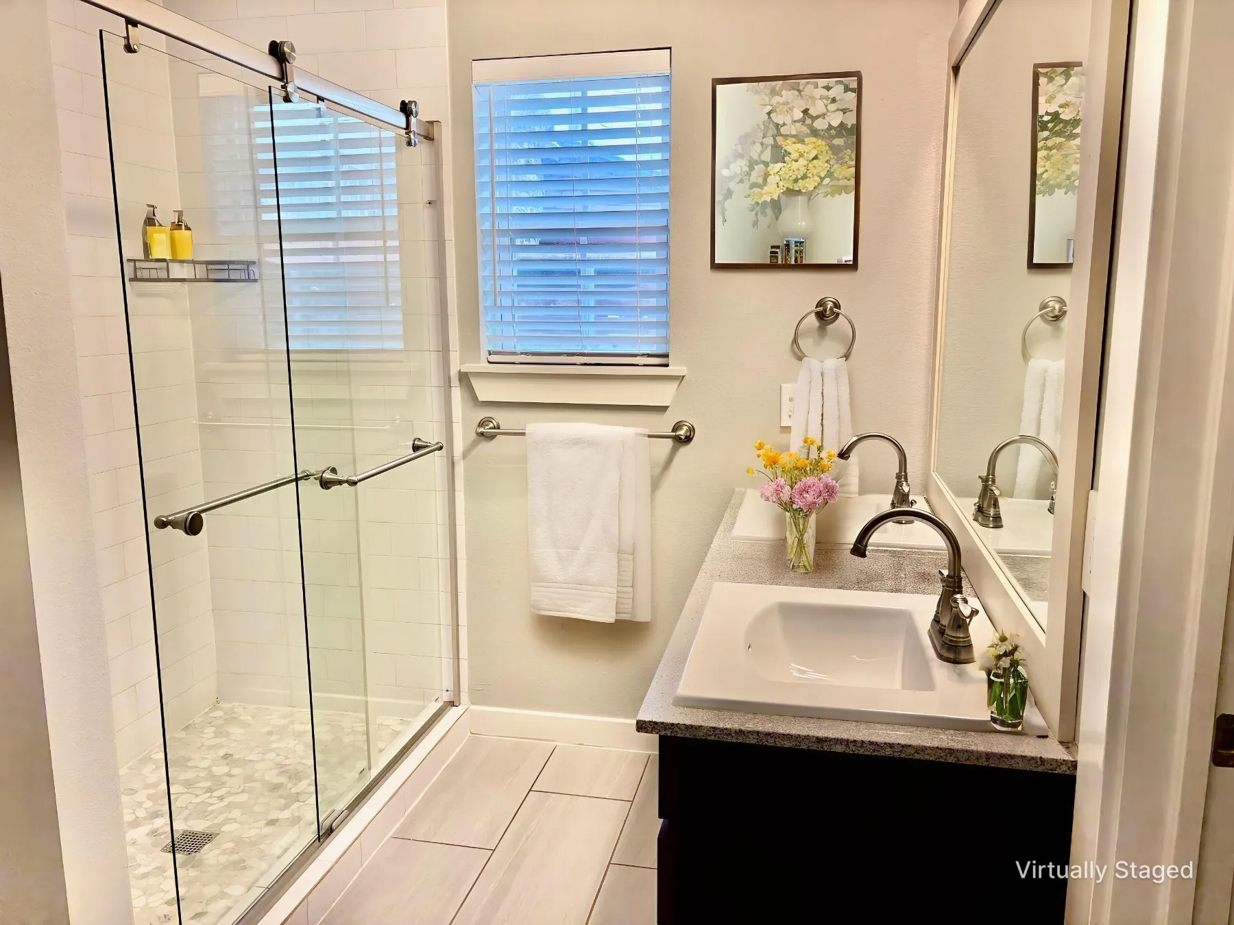 Bathroom featuring a stall shower and double vanity