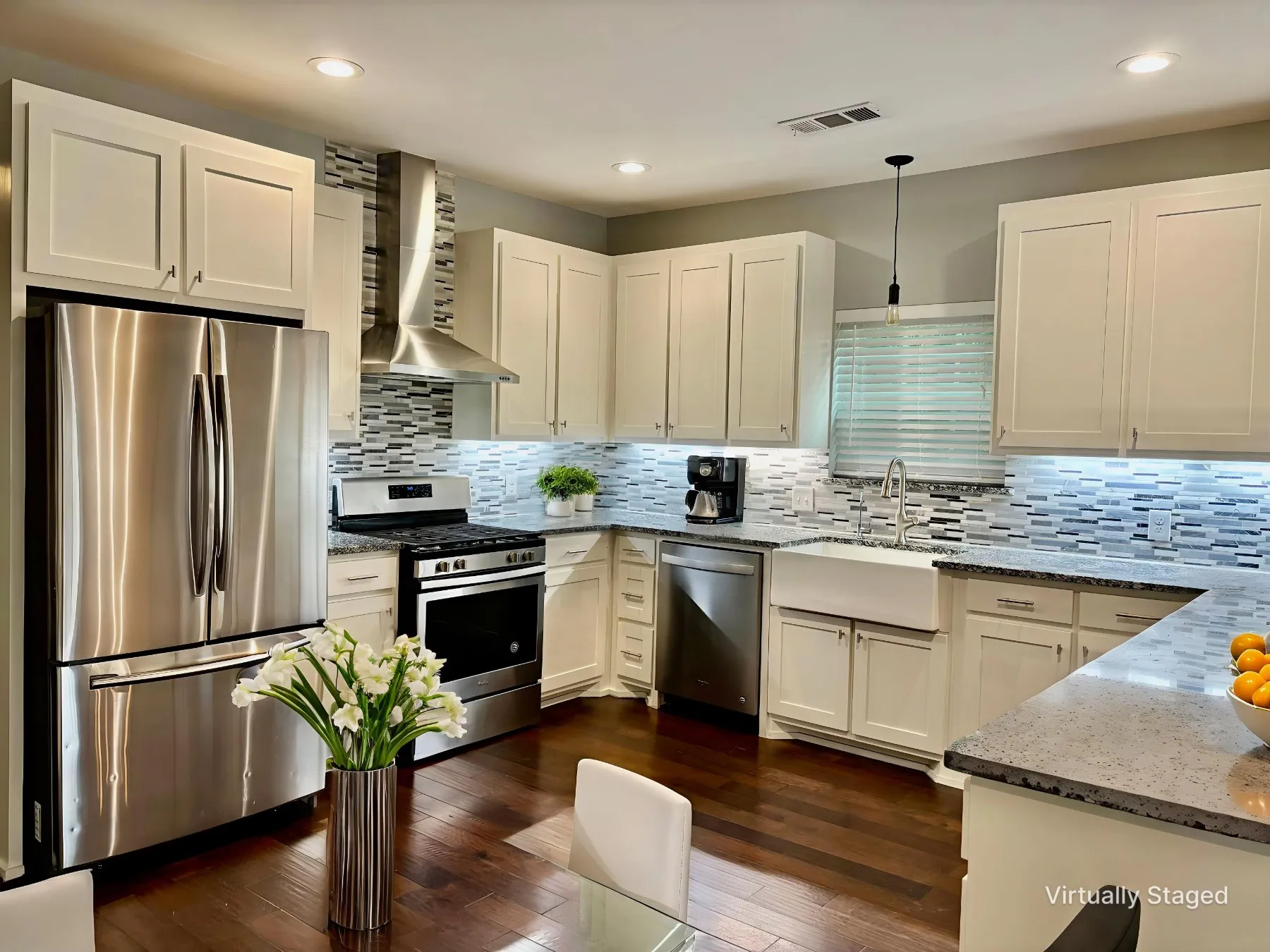 Kitchen with light stone countertops, stainless steel appliances, white cabinetry, and dark wood-style flooring