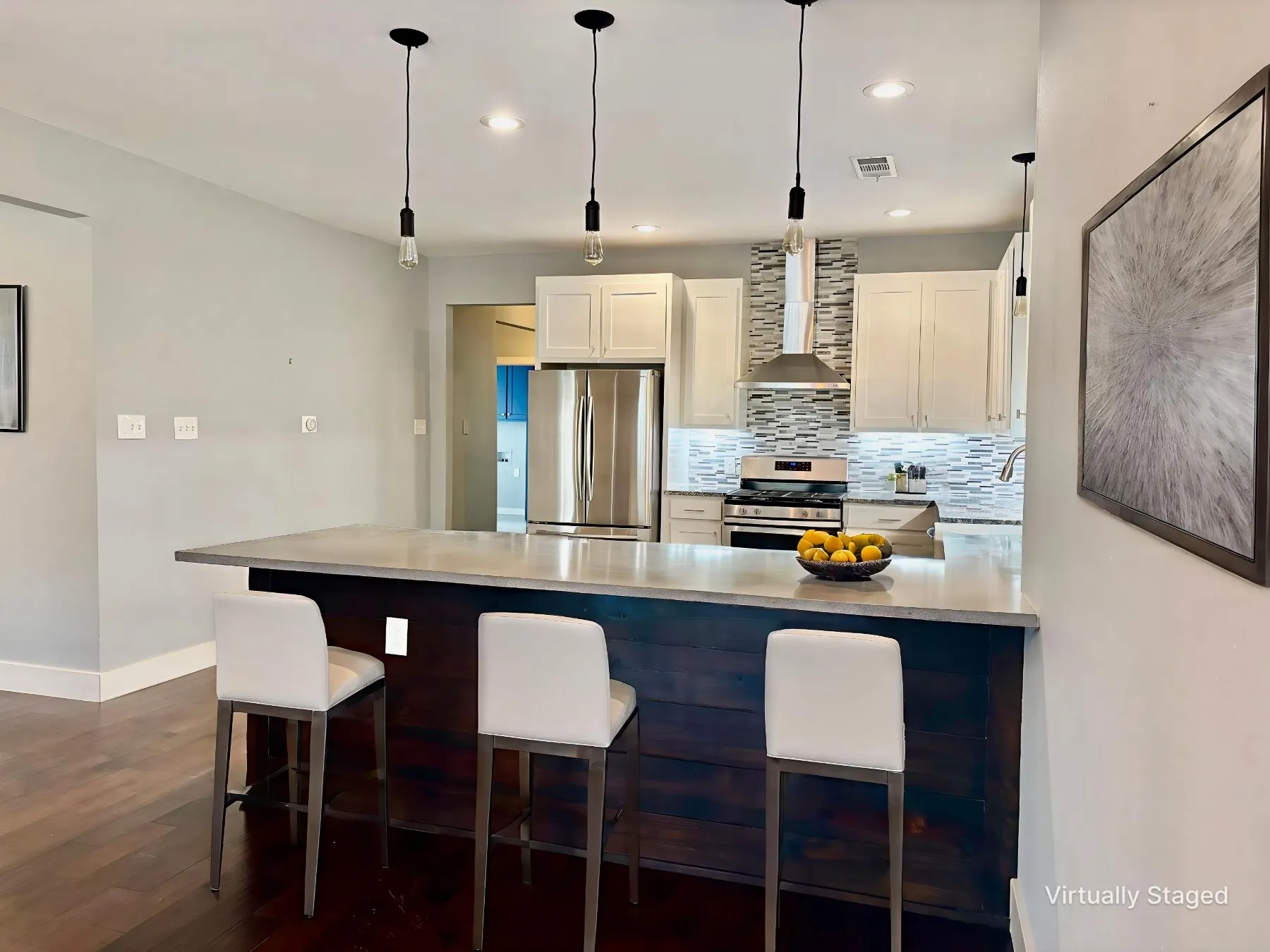 Kitchen featuring a breakfast bar, a peninsula, stainless steel appliances, and hanging light fixtures