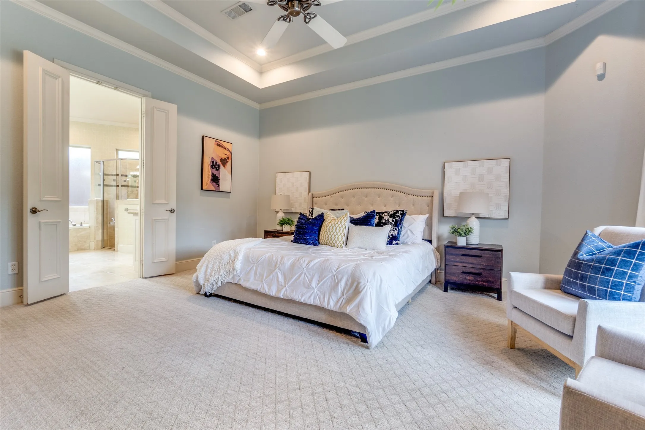Bedroom with light colored carpet, baseboards, ensuite bathroom