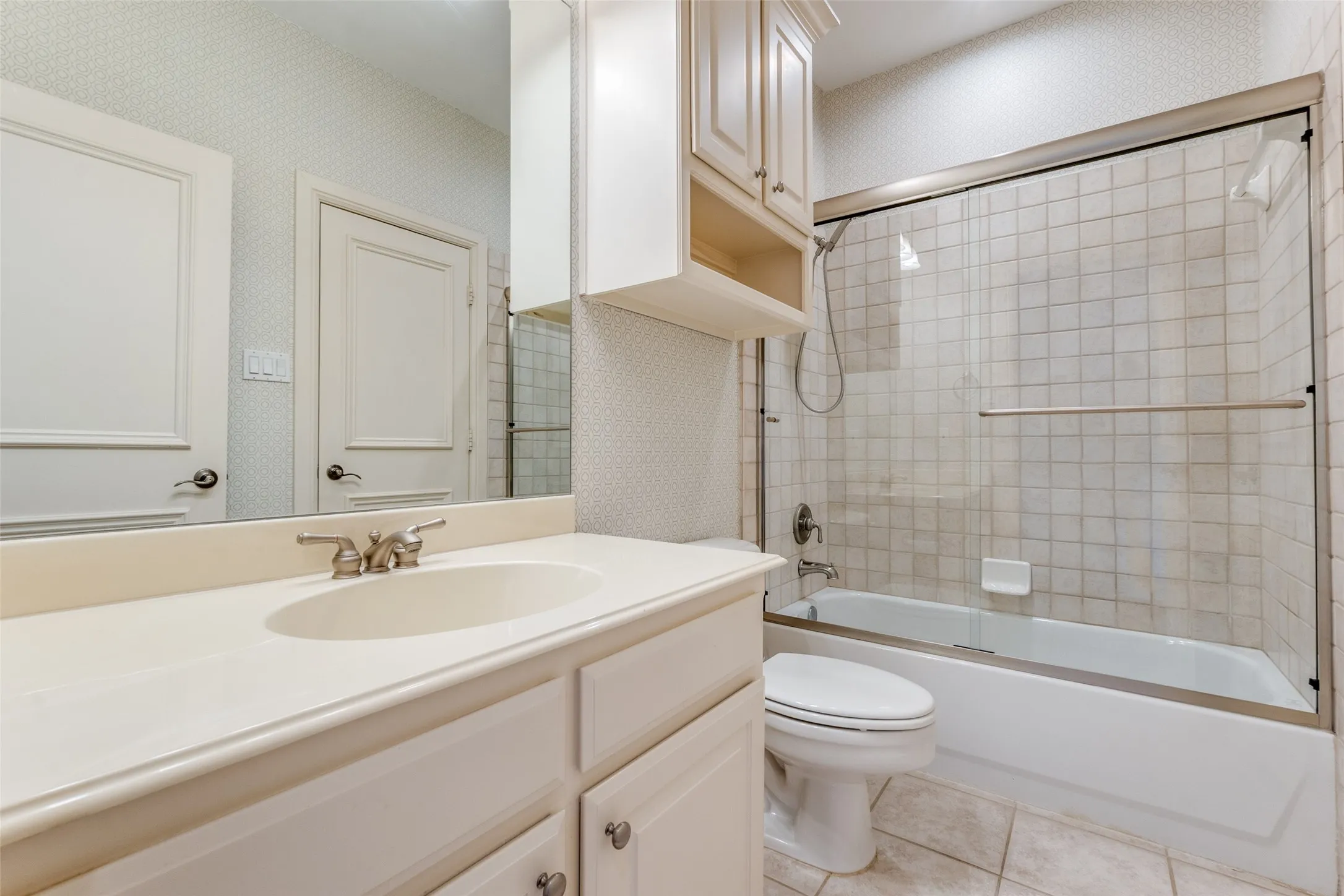 Bathroom featuring vanity, tile patterned flooring, toilet, and  shower combination