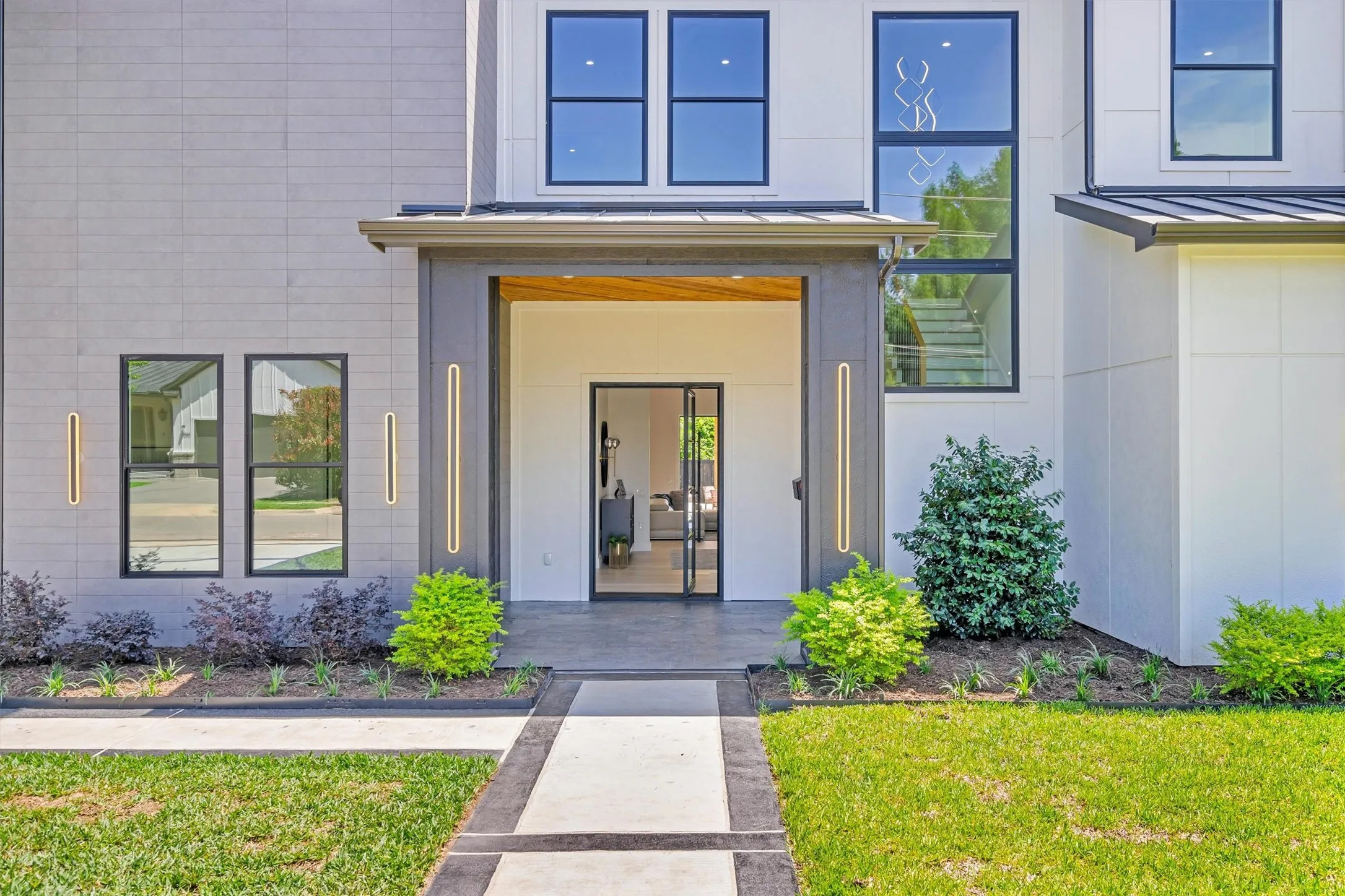 View of exterior entry with a standing seam roof and a lawn