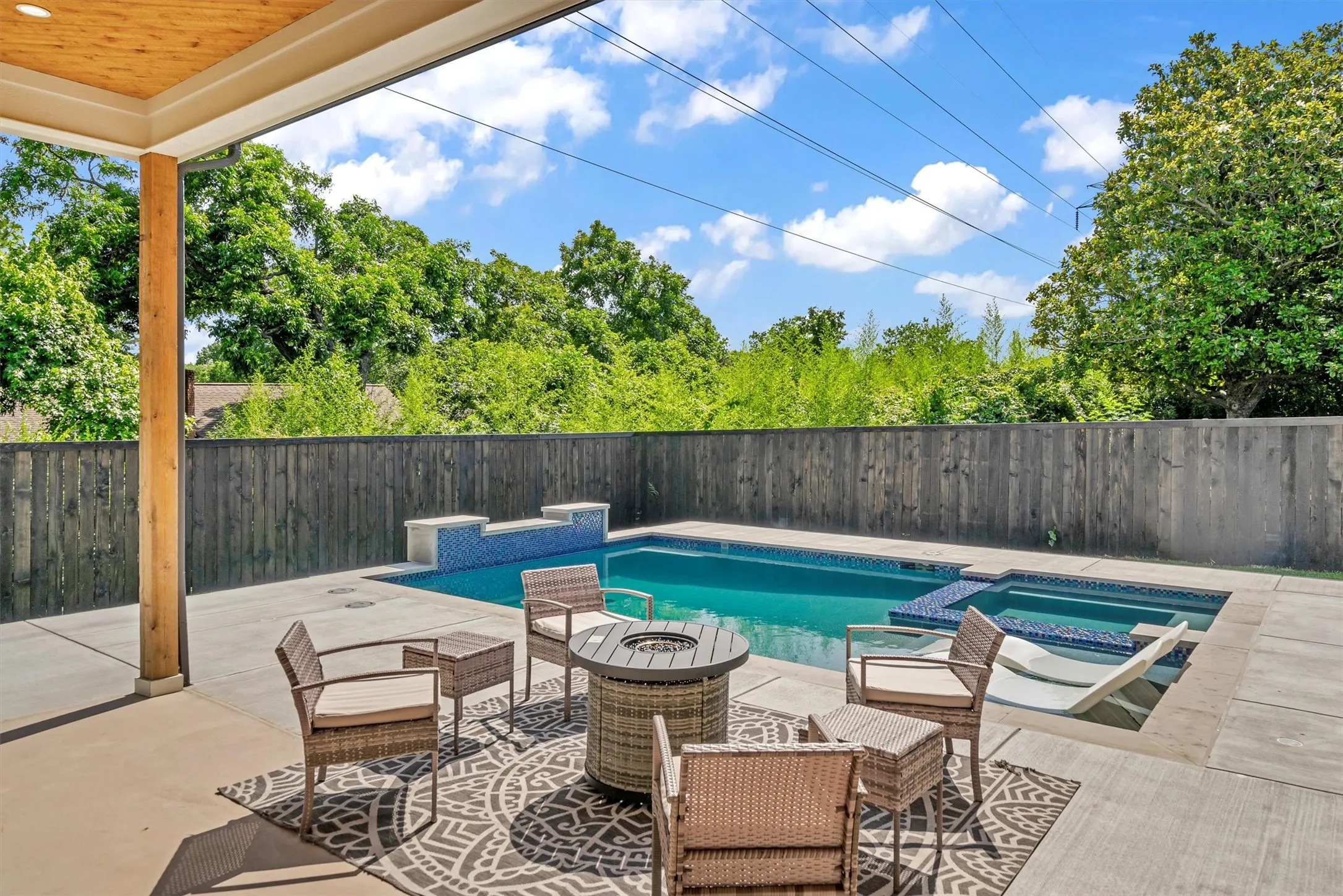 Integrated pool / hot tub featuring a patio, a fenced backyard, and an outdoor fire pit