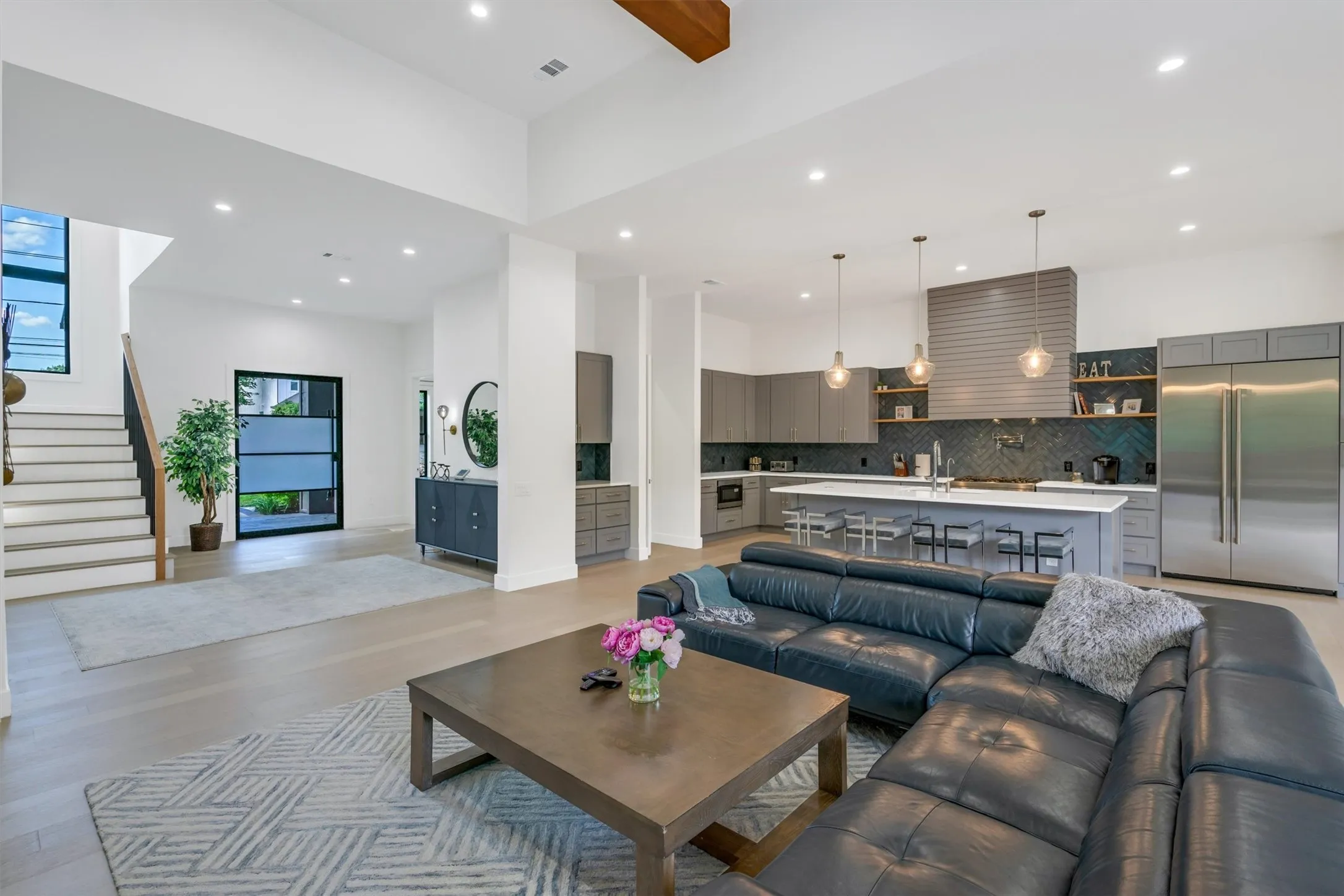Living room featuring light wood-type flooring, recessed lighting, and beamed ceiling