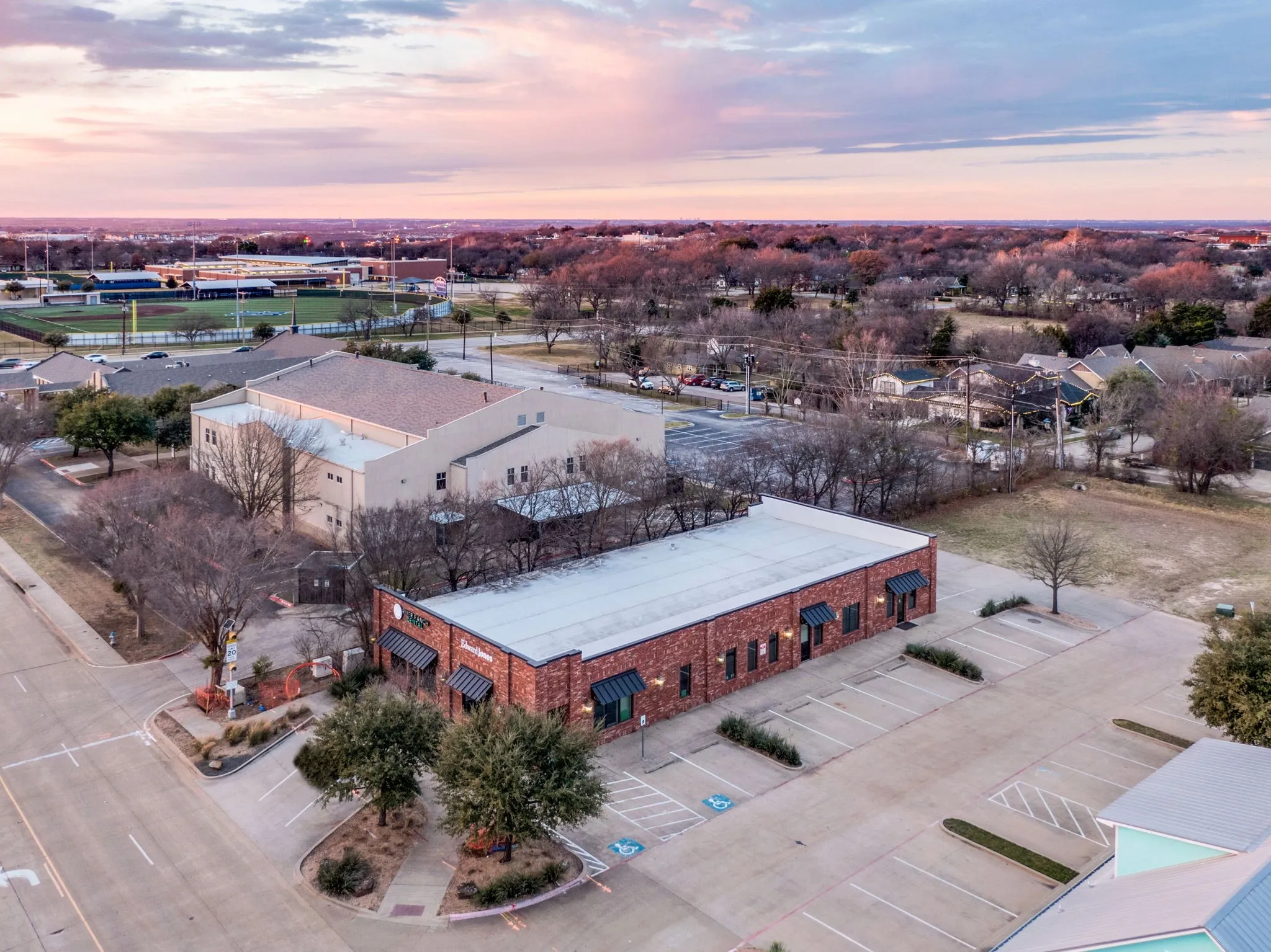 Aerial view offering a broader look at the building and its well-established surroundings.