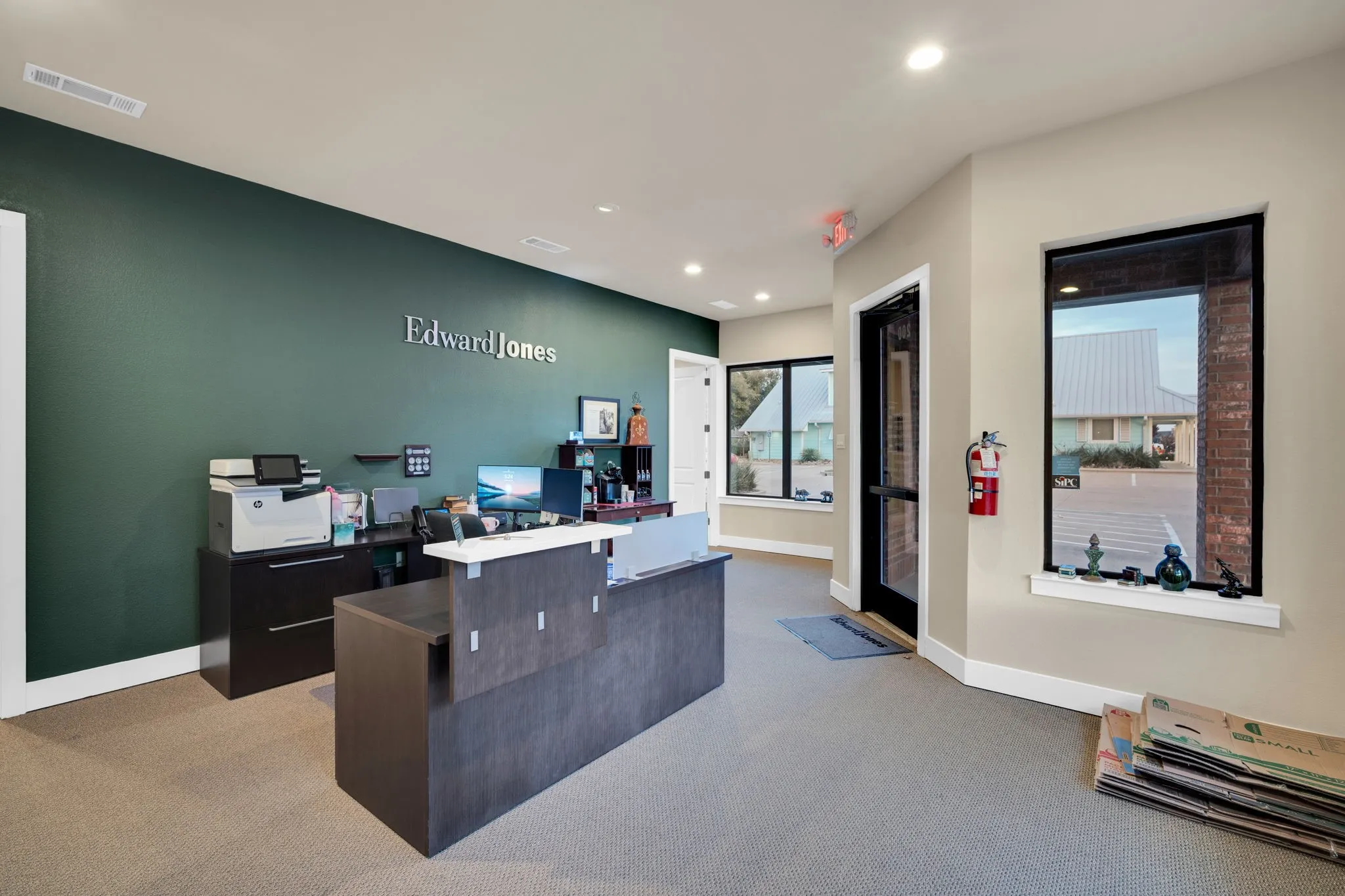 Reception area featuring an eye-catching accent wall and convenient exterior access.