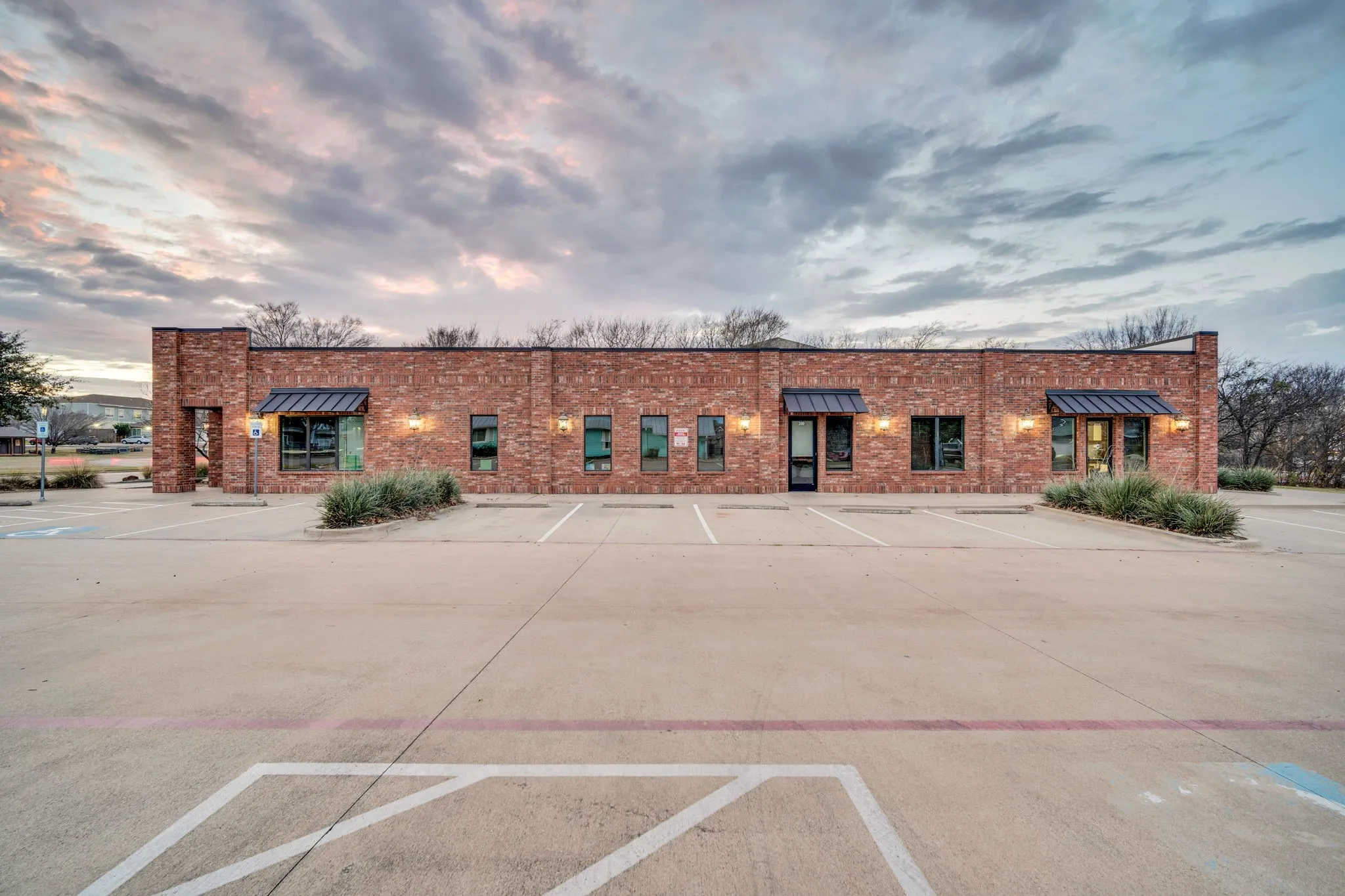 Full exterior view of the building, highlighting its clean architectural lines and generous paved parking area.