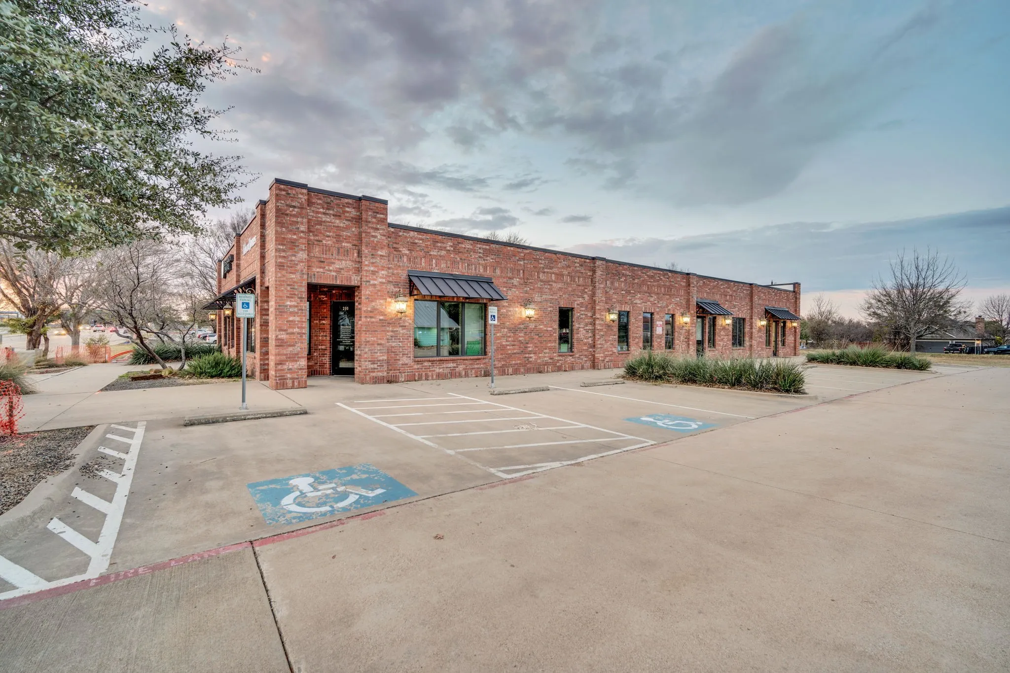 Side view of the building showcasing its brick exterior and ample parking.
