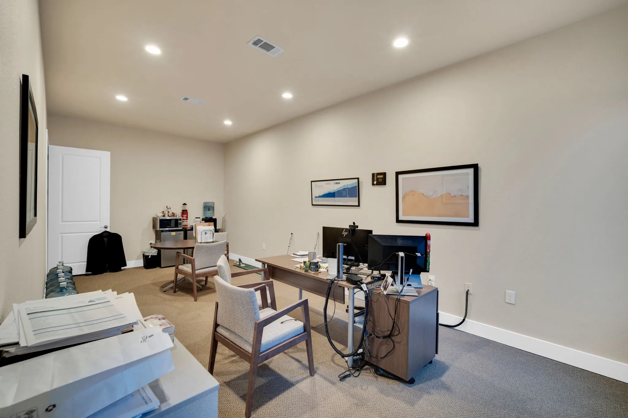Functional office area offering flexible space for workstations or meetings.