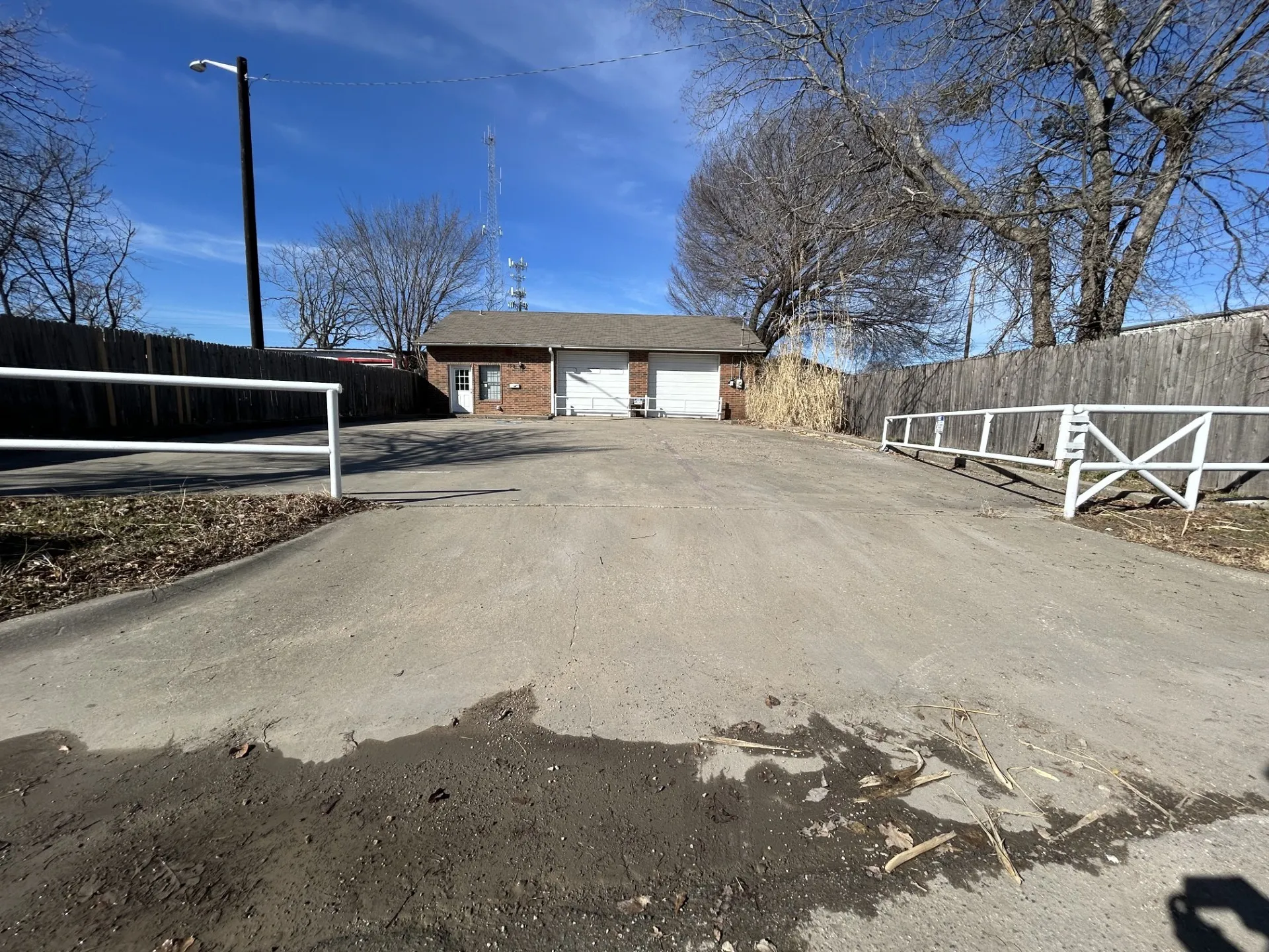 Front view of the brick building with driveway and parking in front.