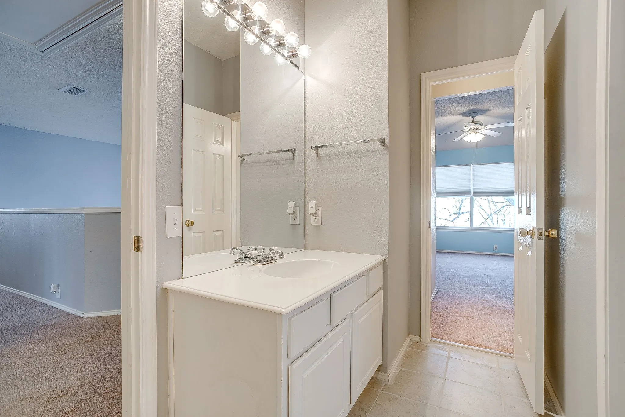 Bathroom featuring light carpet, vanity, a textured ceiling, and ceiling fan