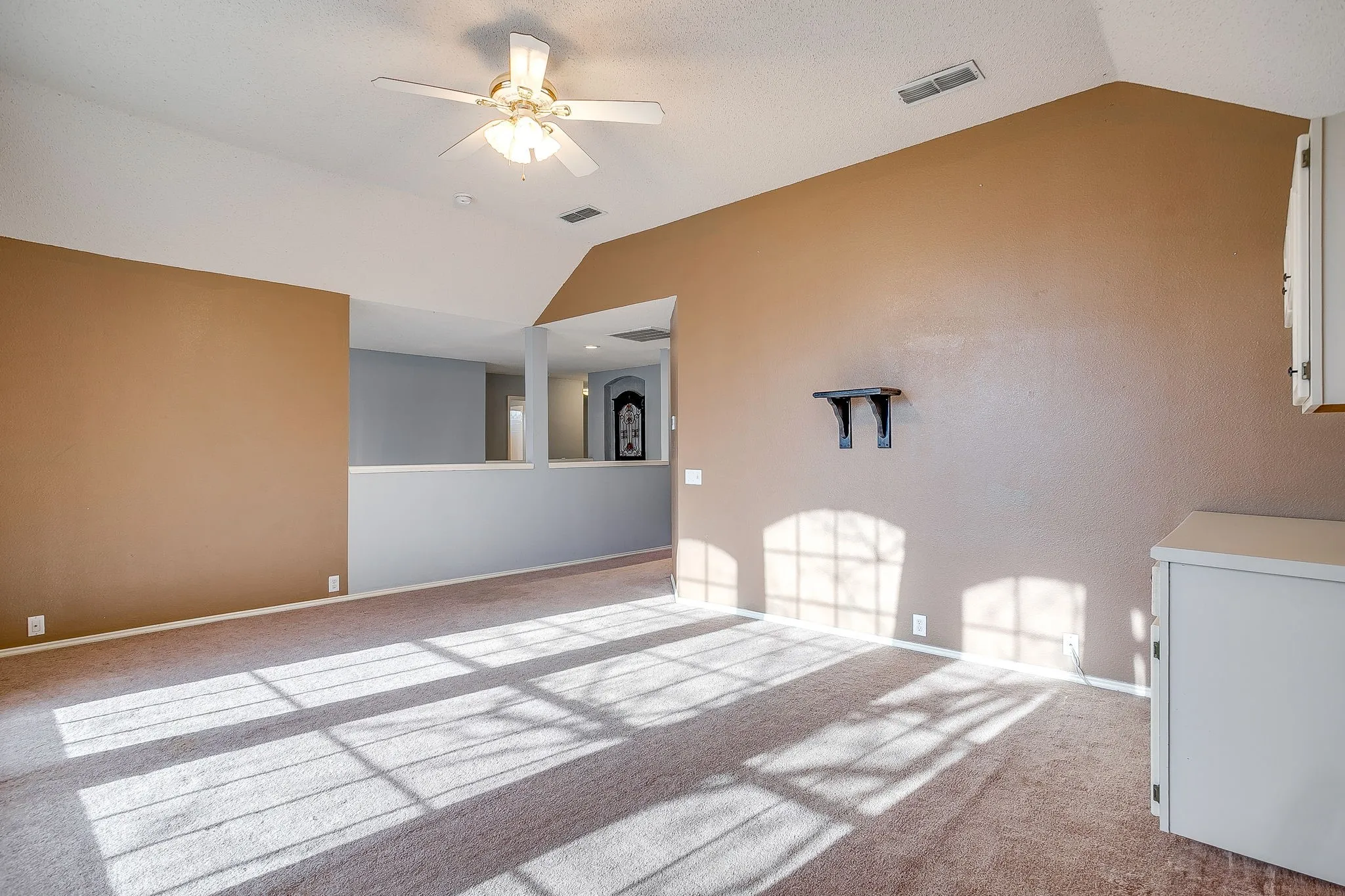 Carpeted spare room featuring a ceiling fan and baseboards