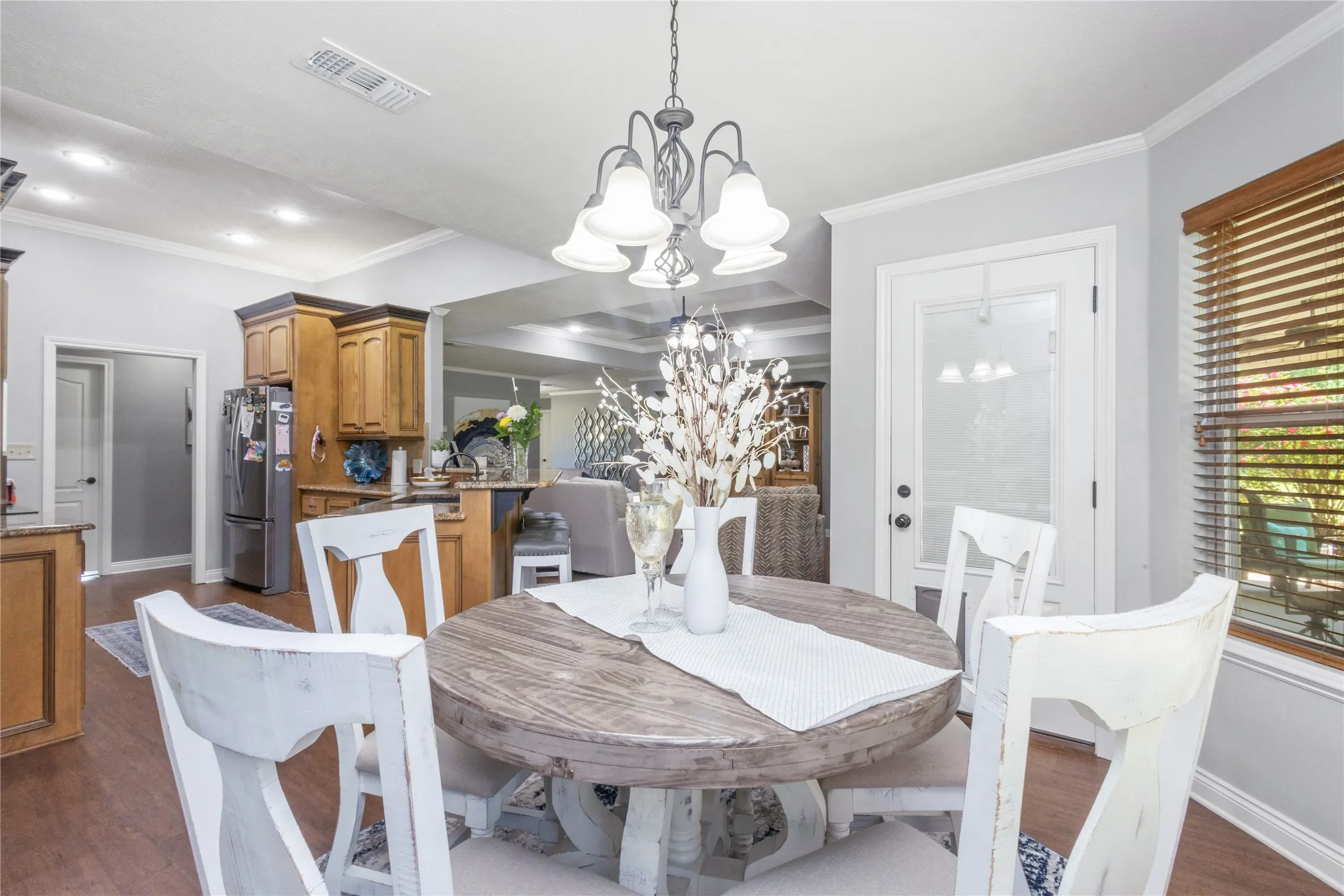 Dining room featuring suspended lighting, dark wood-style flooring, and ornamental molding