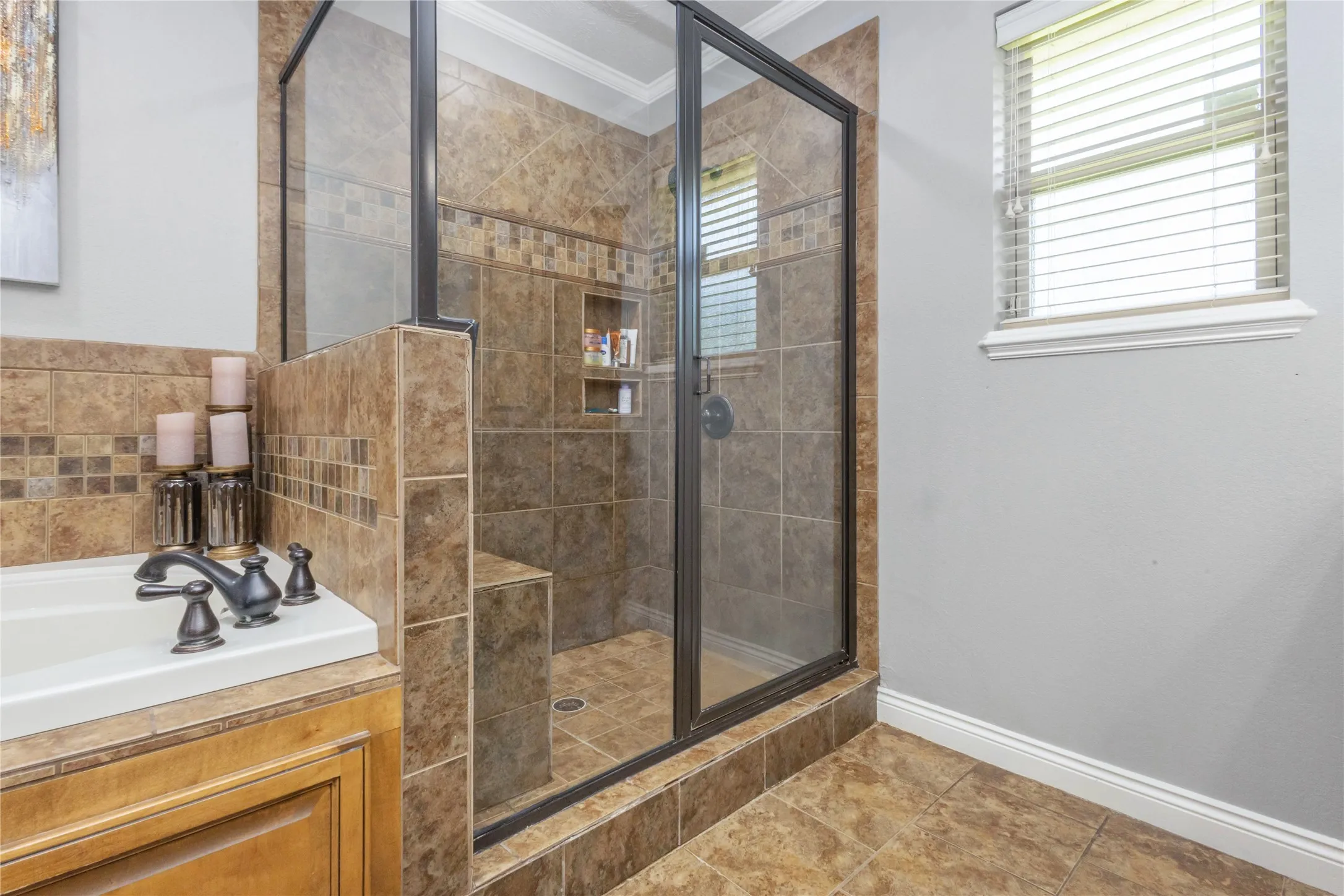 Bathroom with a stall shower, crown molding, and a garden tub
