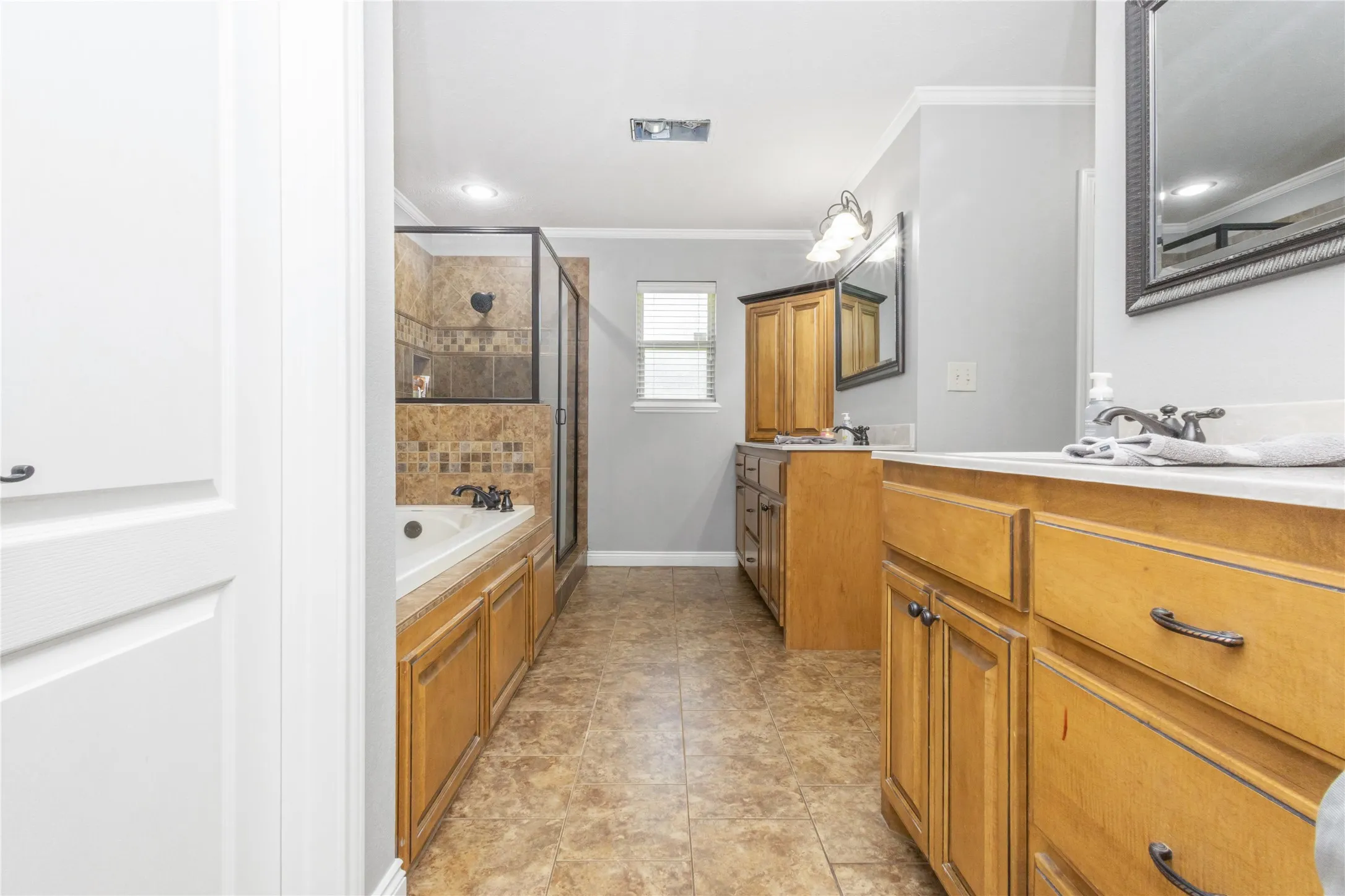 Full bathroom featuring a bath, a stall shower, vanity, crown molding, and recessed lighting