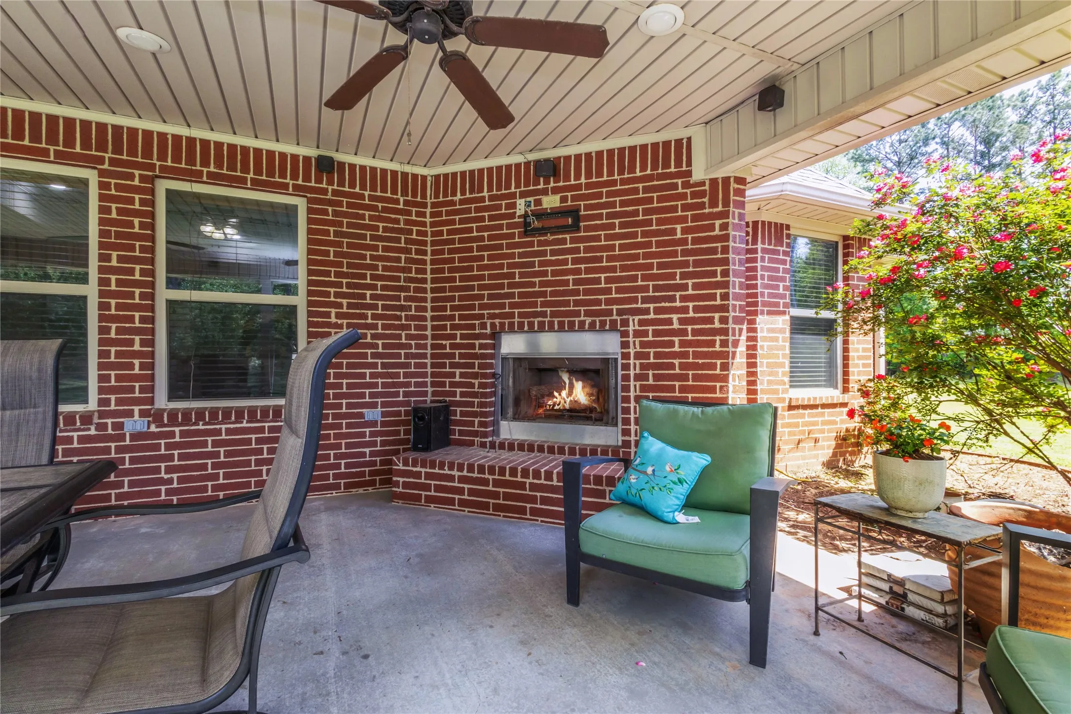 View of patio / terrace with a ceiling fan and an outdoor brick fireplace