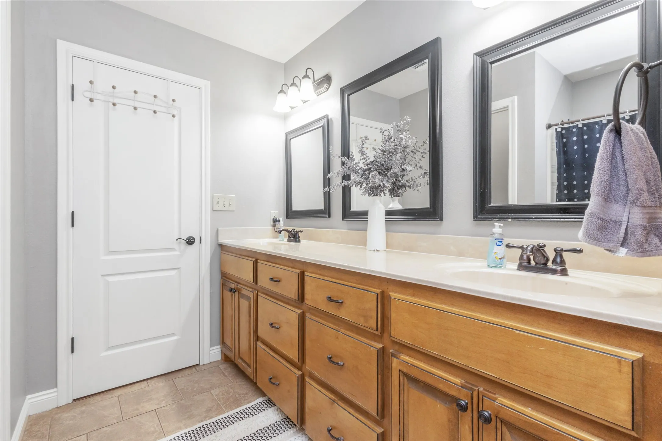 Bathroom featuring double vanity and light tile patterned floors