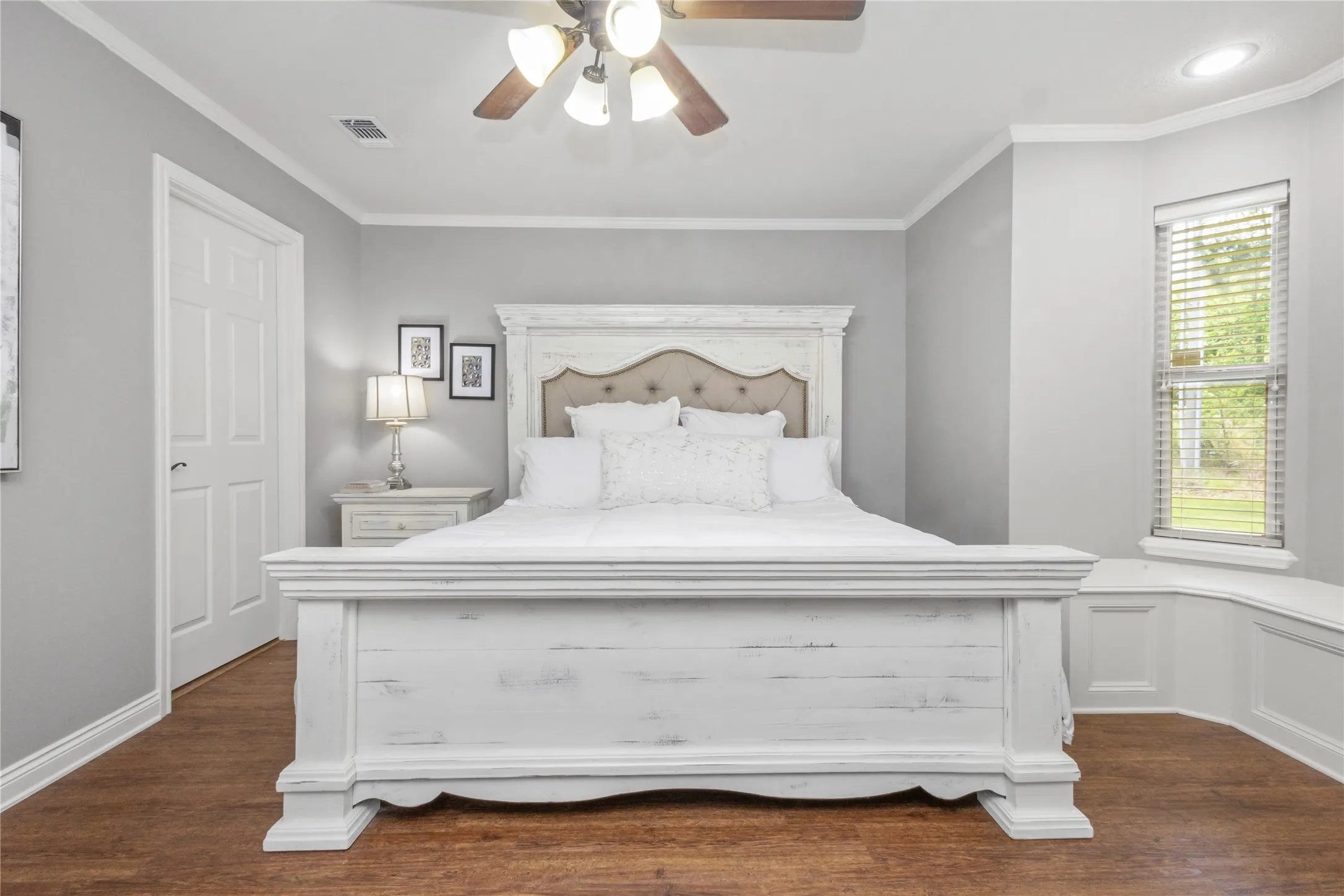 Bedroom with ornamental molding, dark wood finished floors, and ceiling fan