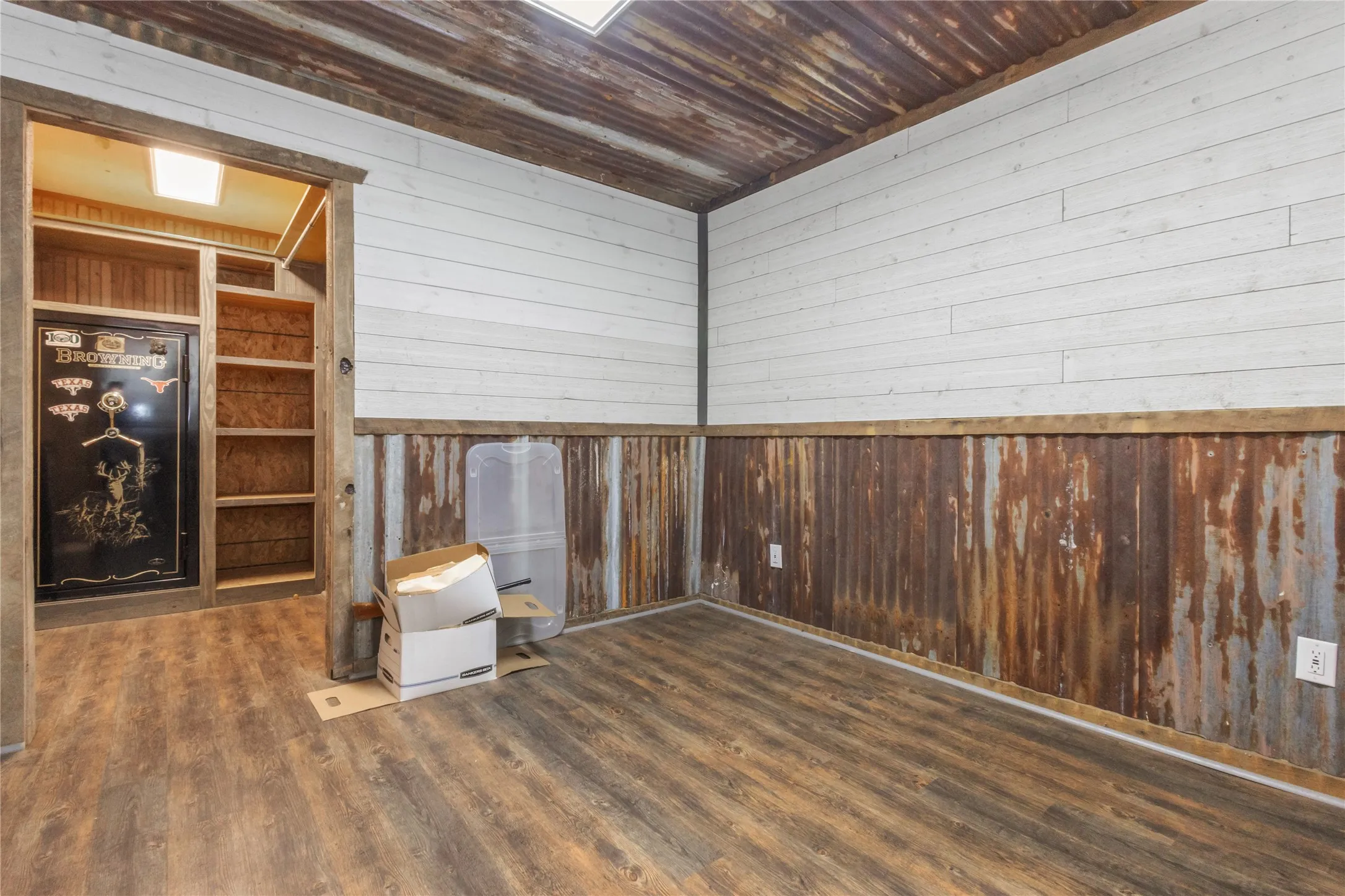 Spare room featuring wood walls, dark wood finished floors, and a wainscoted wall