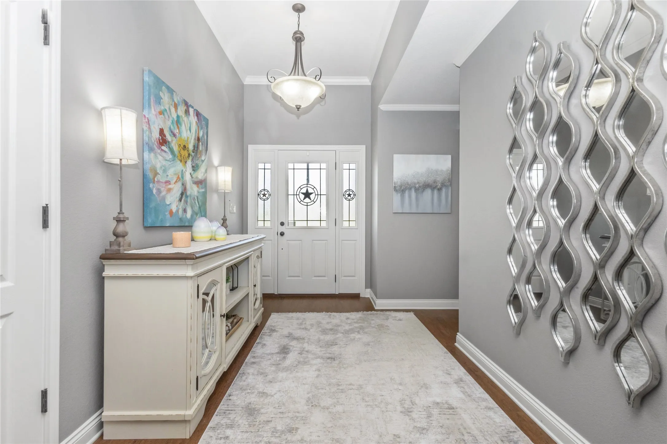 Entrance foyer featuring crown molding and dark wood-style floors