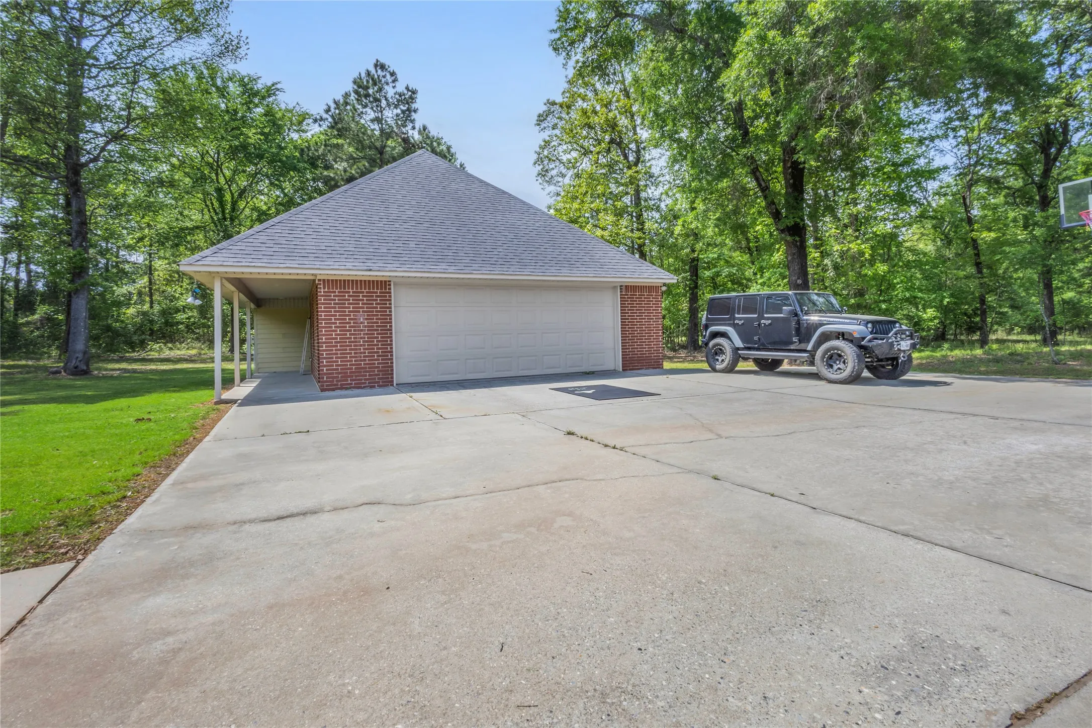 Garage with driveway and view of scattered trees