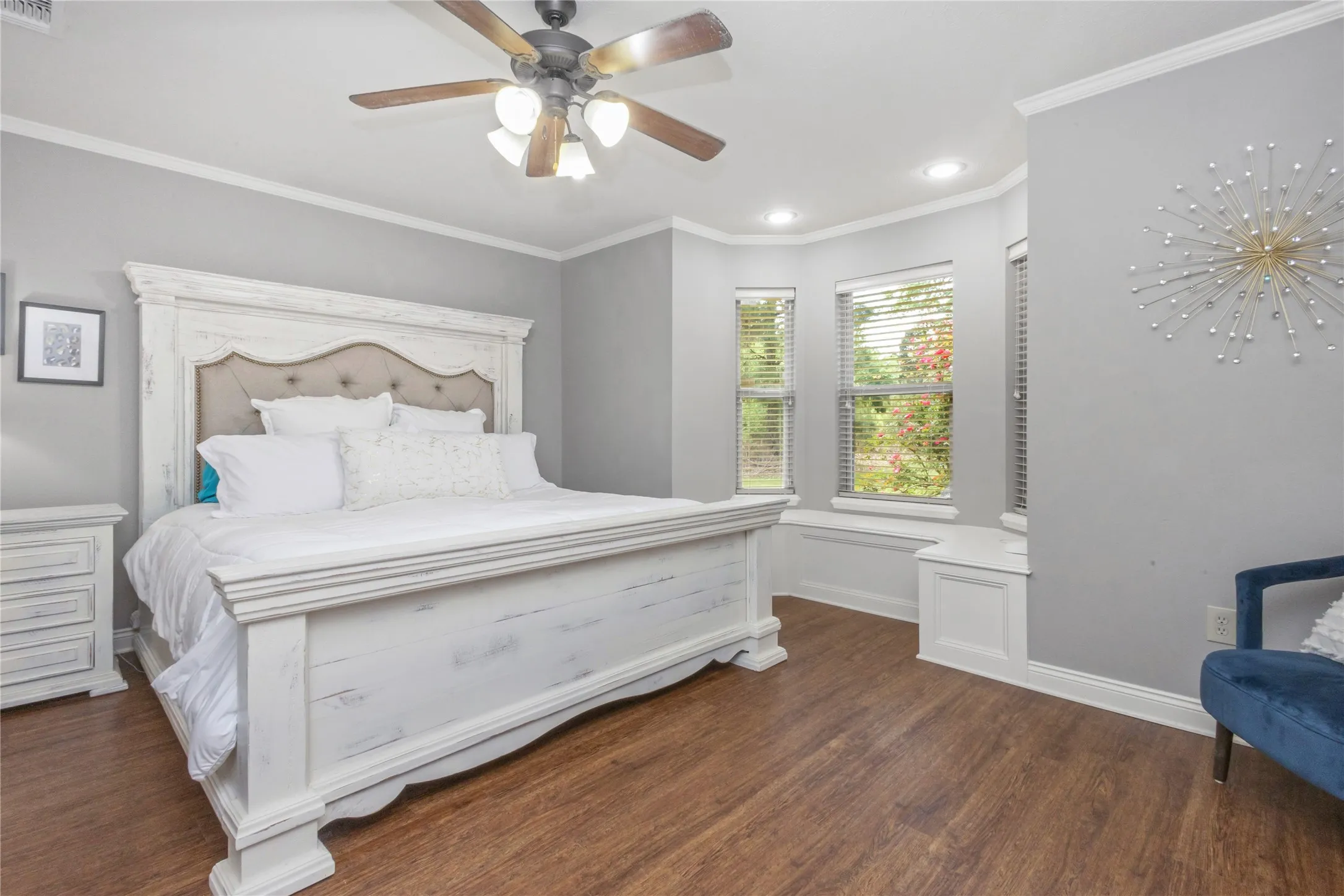 Bedroom with dark wood finished floors, crown molding, and a ceiling fan