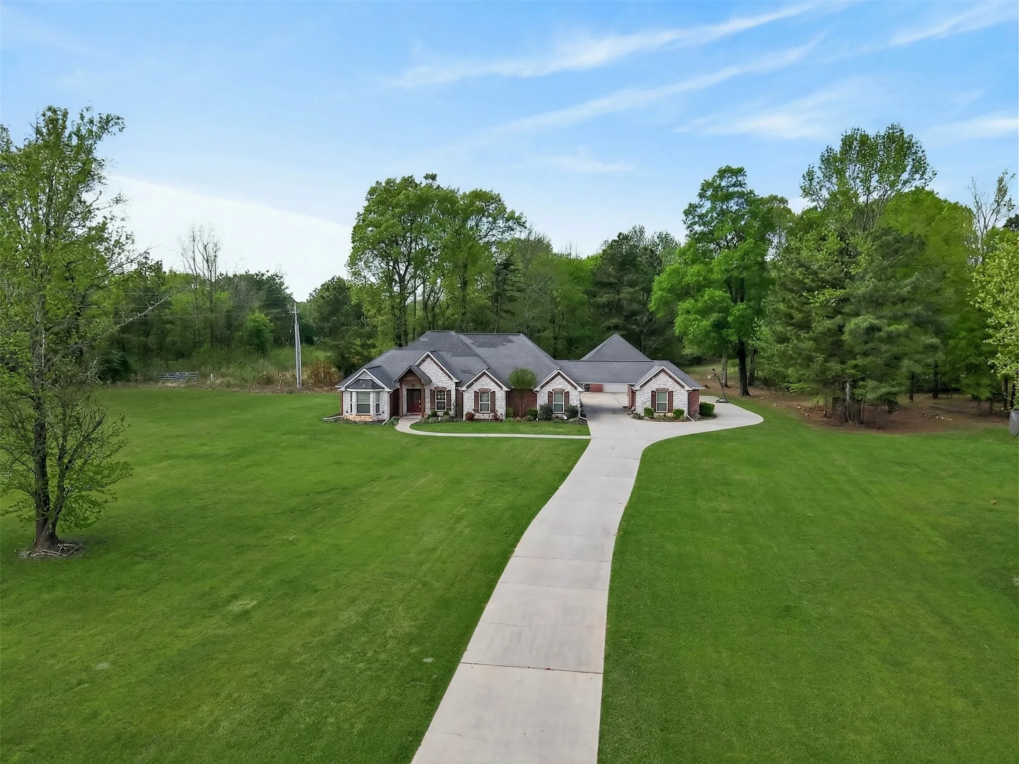 View of front of house with a front lawn and view of scattered trees