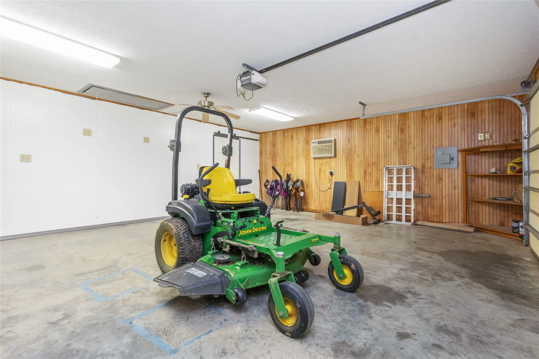 Garage with wood walls and a garage door opener