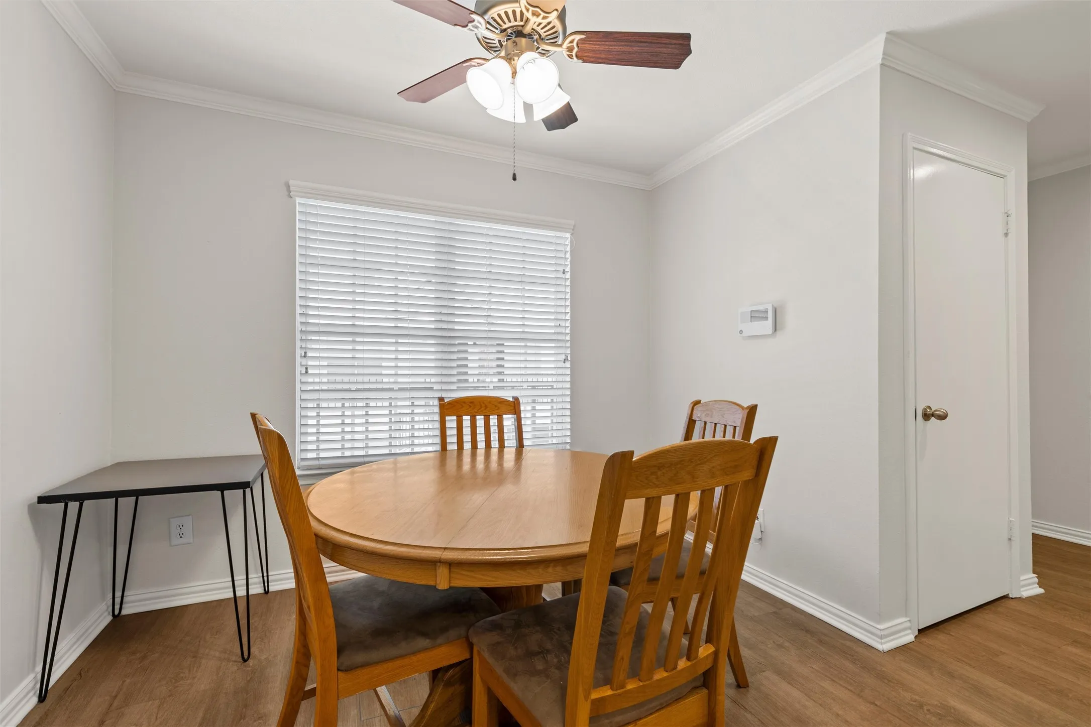 Dining area with ceiling fan, crown molding and great cabinet storage.