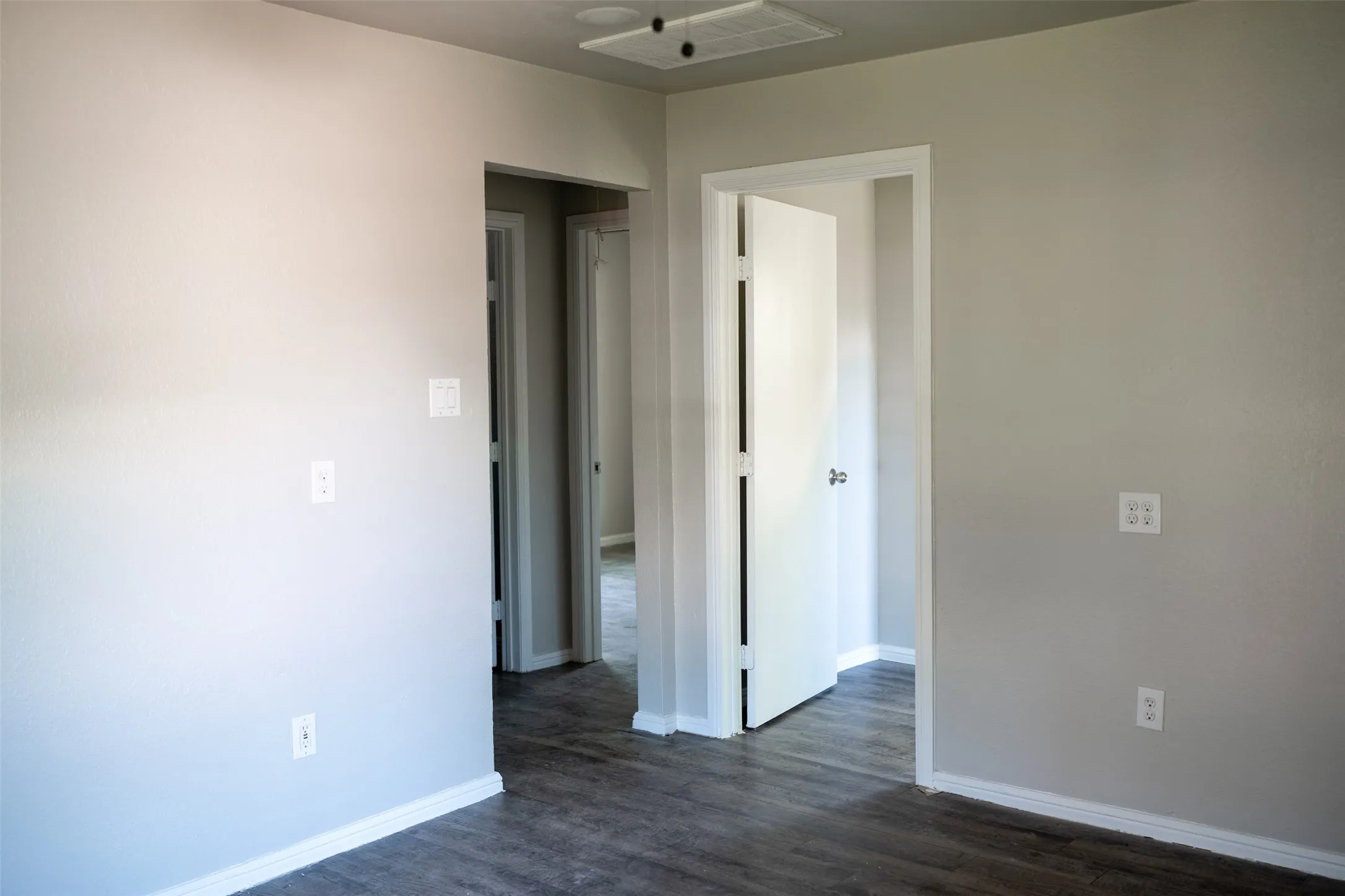 Spare room featuring baseboards and dark wood finished floors